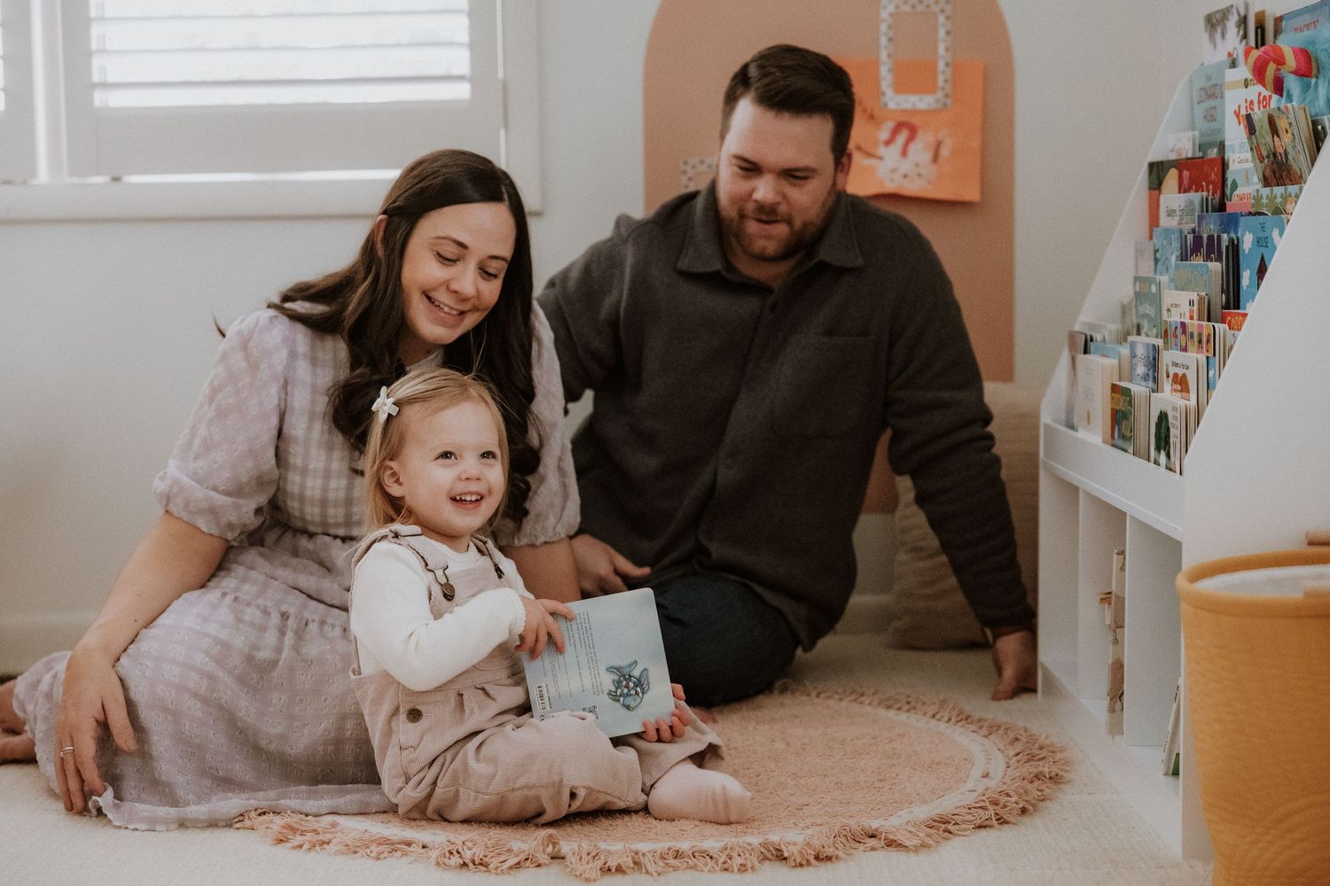 Family sitting together on carpet during intimate indoor photoshoot.