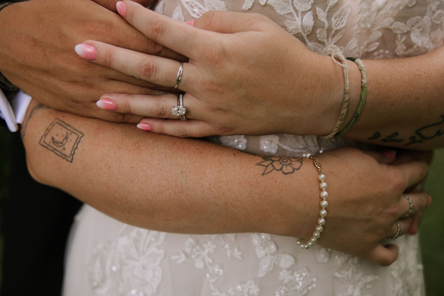 Close-up shots of hands with rings and pink nail polish against a white lace background.