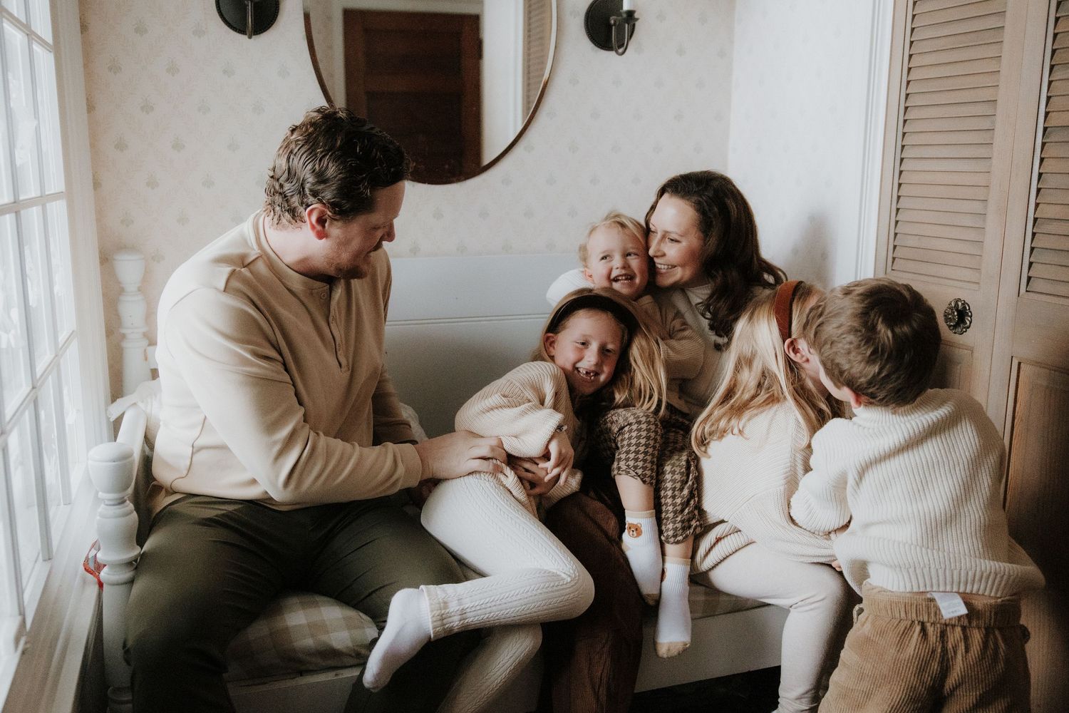 Intimate family lifestyle photography session showing tender moments in a cozy indoor setting.