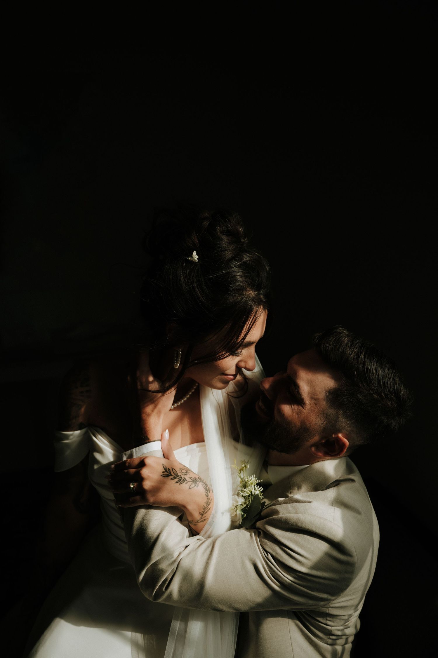 Artistic black and white intimate wedding portraits in dramatic low light setting.