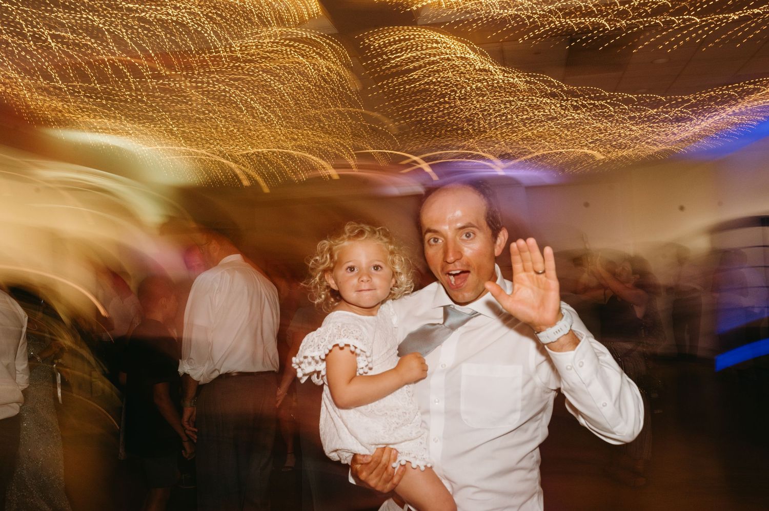 Motion-blurred photos capture dancing and celebration moments at an indoor wedding reception.