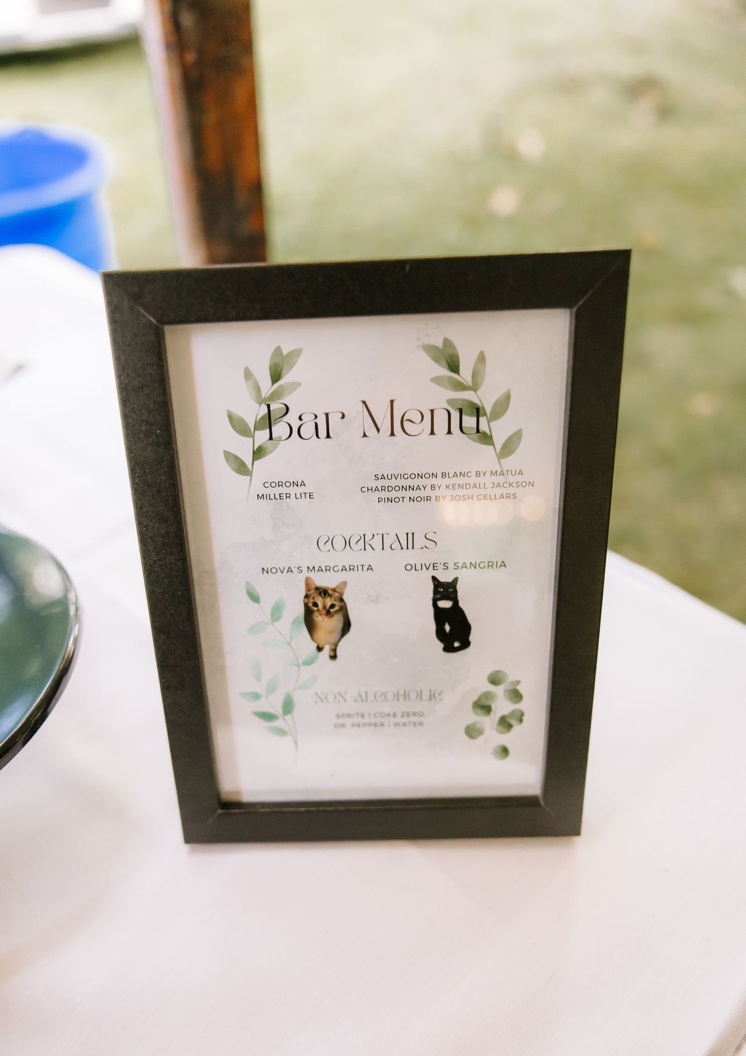 Wedding menu cards with delicate leaf designs and butterfly decorations displayed on a white table.