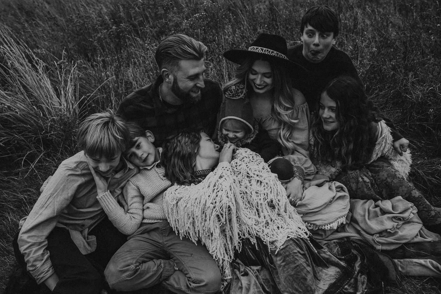 Group of people lying together in grass creating intimate candid moments.