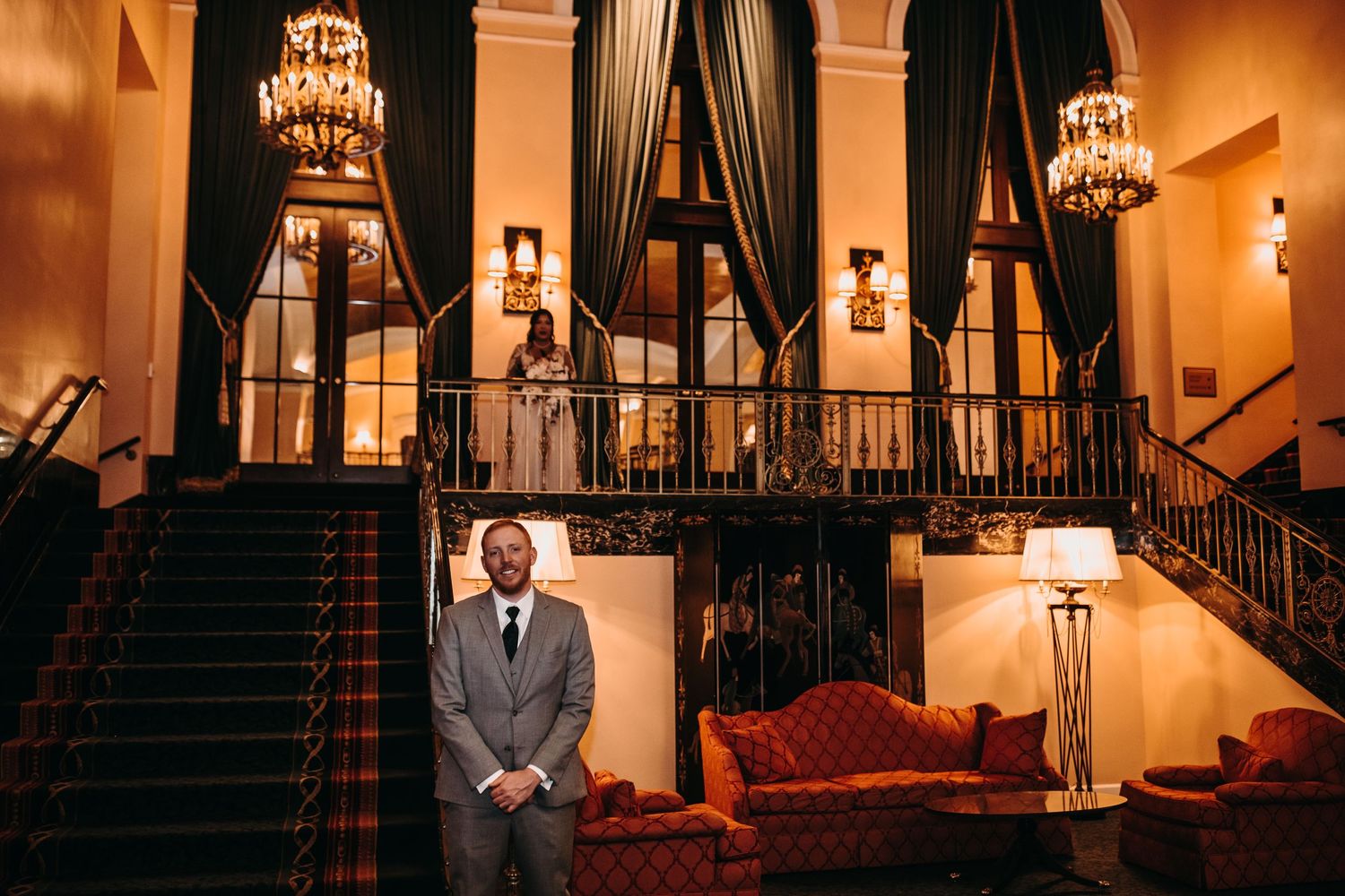 Elegant venue interior with grand staircase, chandeliers, and dramatic lighting.