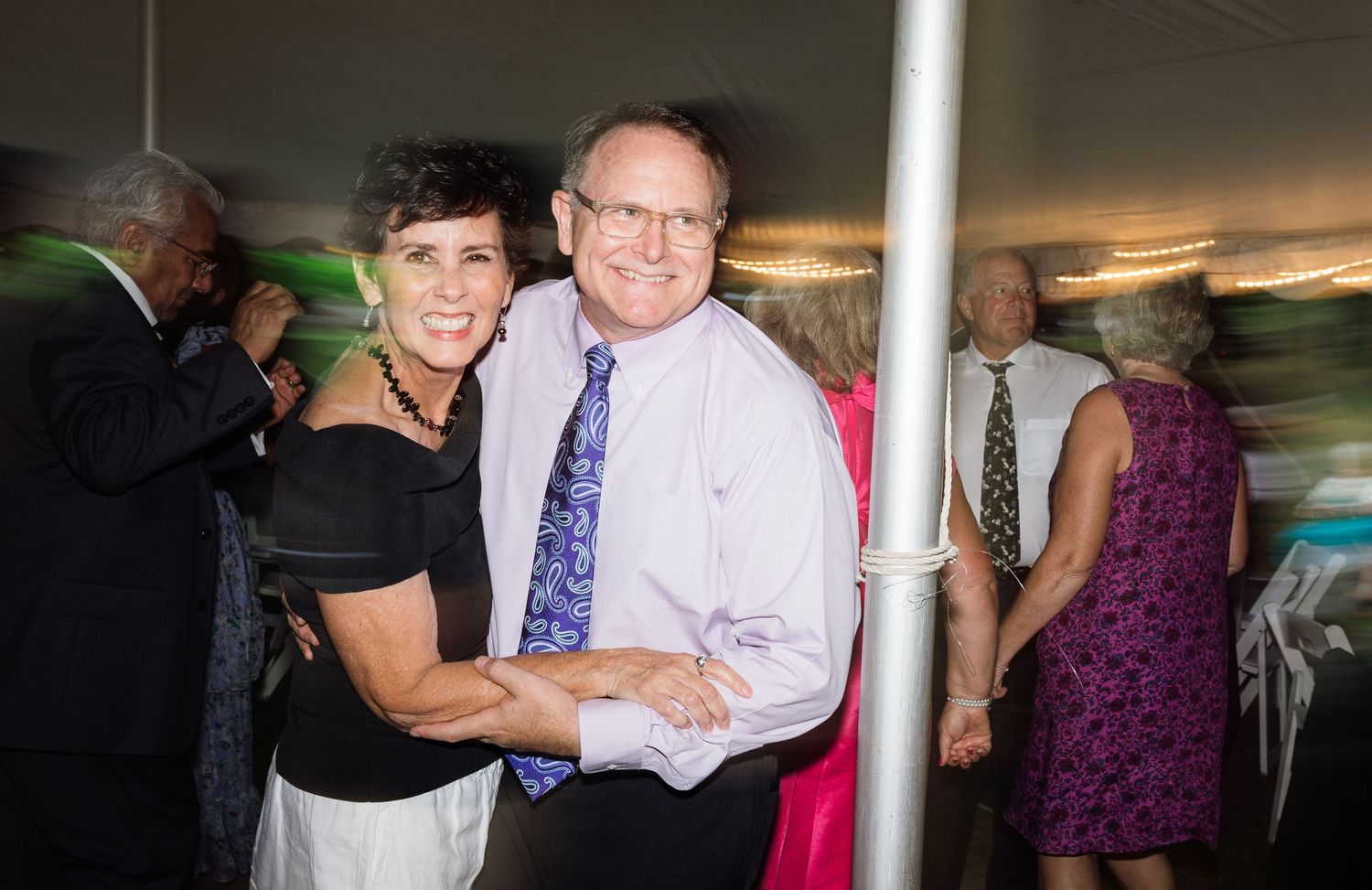 Wedding guests dancing and celebrating at an indoor reception.