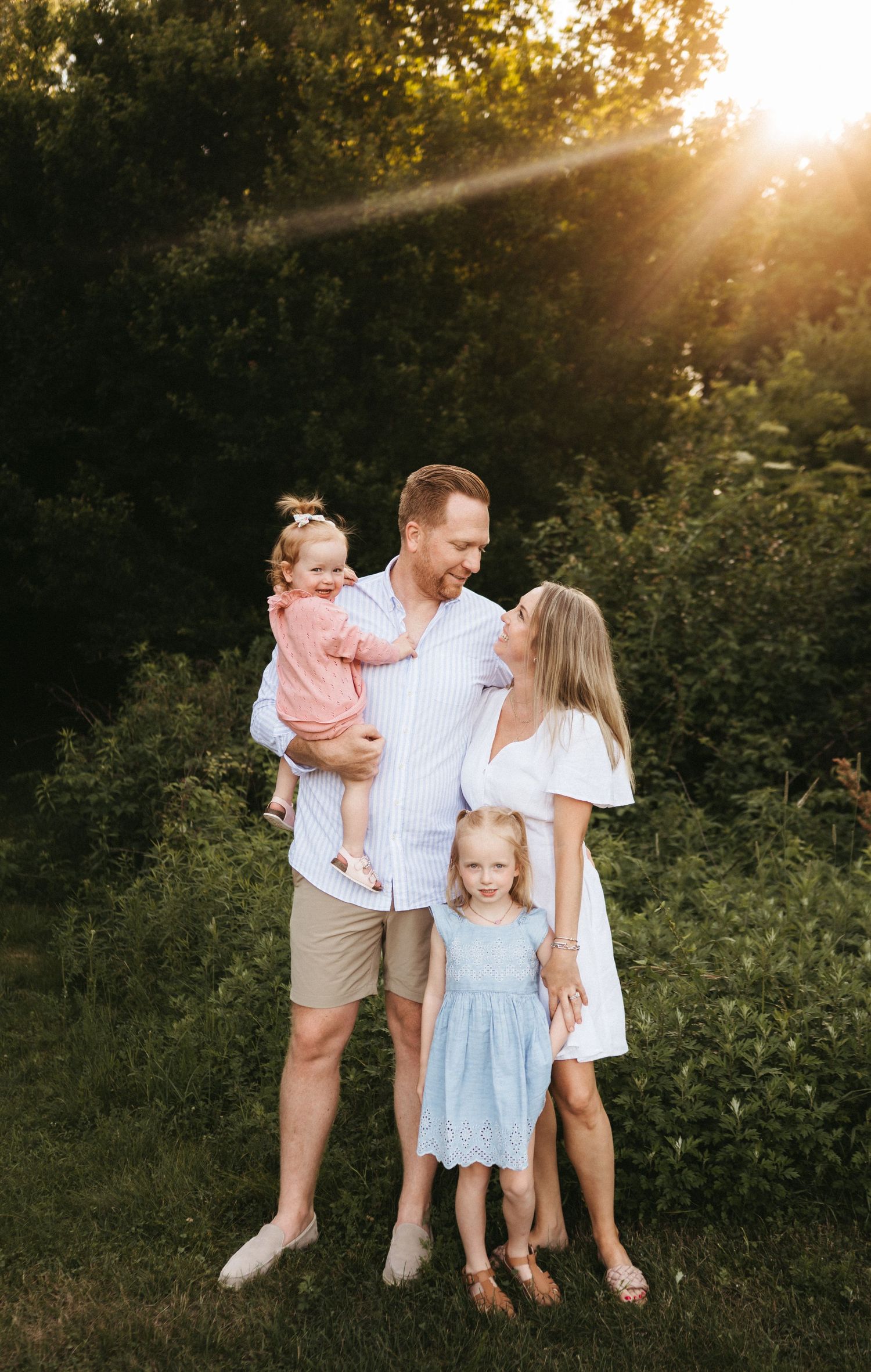 A family enjoying a golden sunset moment together in a natural outdoor setting.