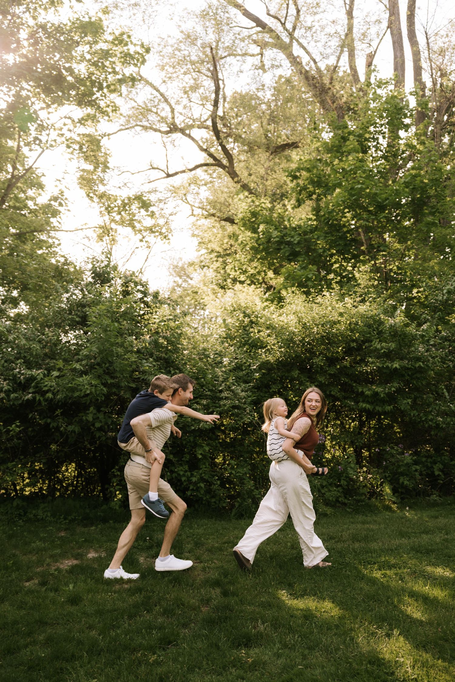 Family playing together in a lush green backyard on a sunny day.