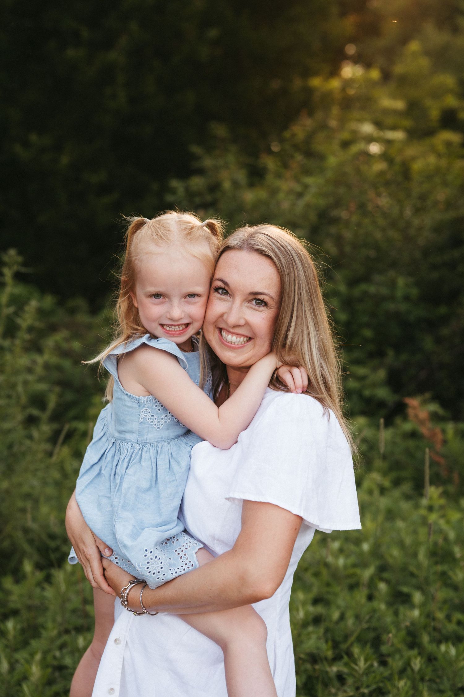 A tender embrace captured during an outdoor family photo session with soft natural lighting.