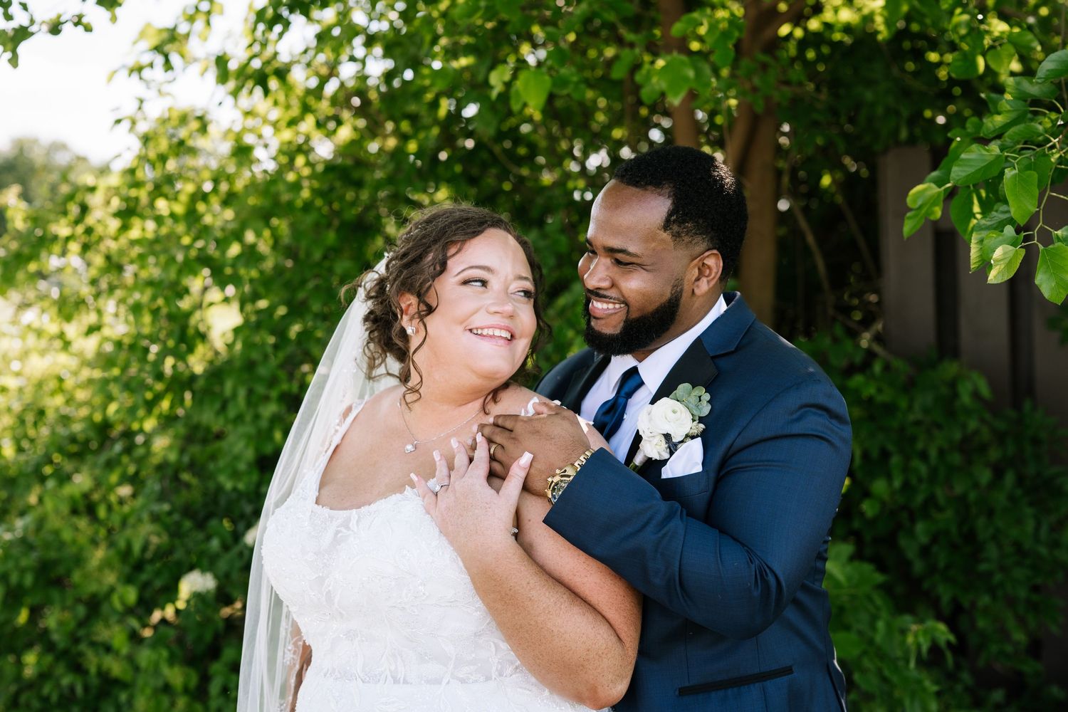 Wedding couple sharing intimate moment in lush garden setting.