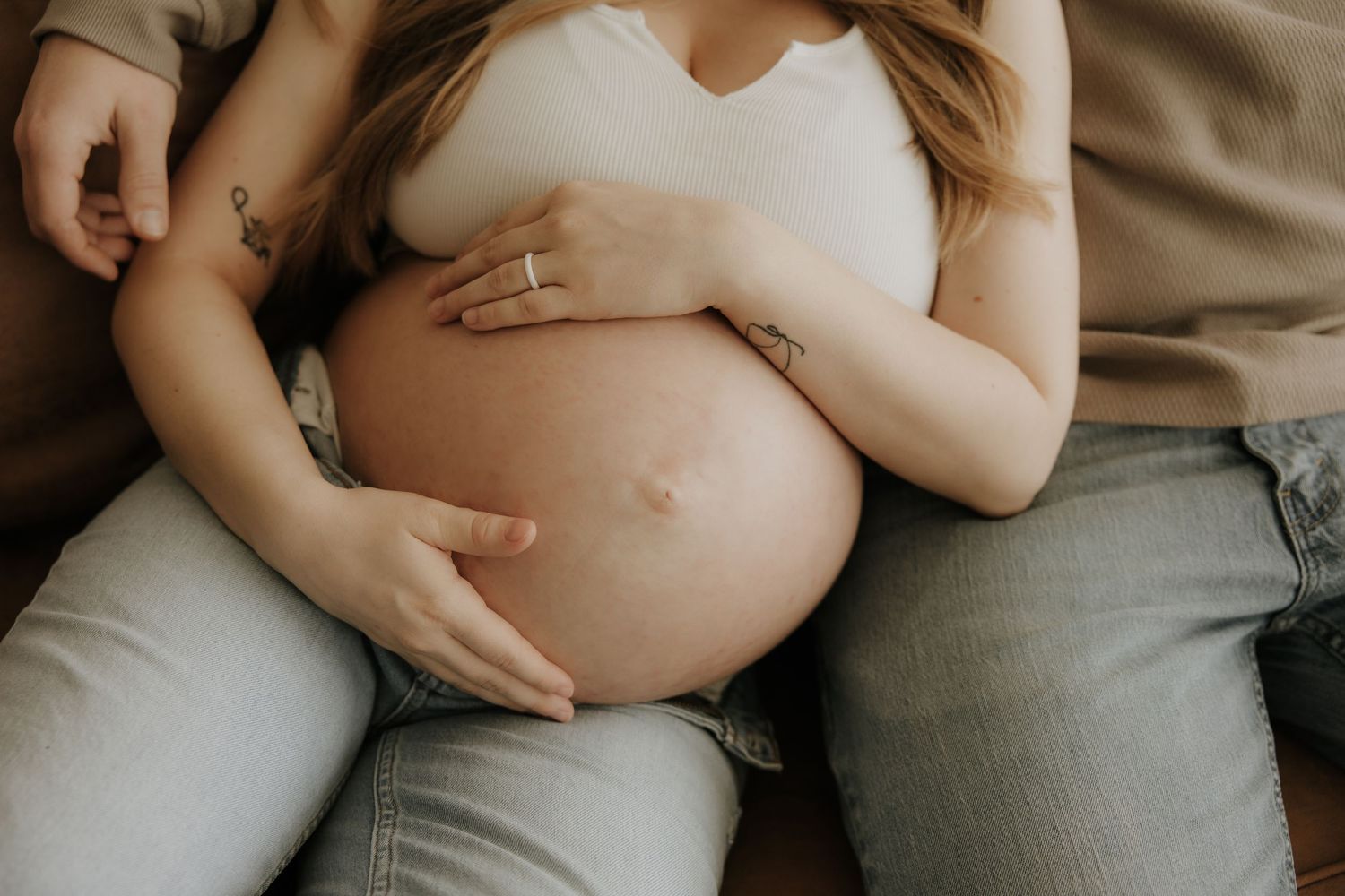 Close-up maternity photos focusing on gentle hands cradling baby bump.