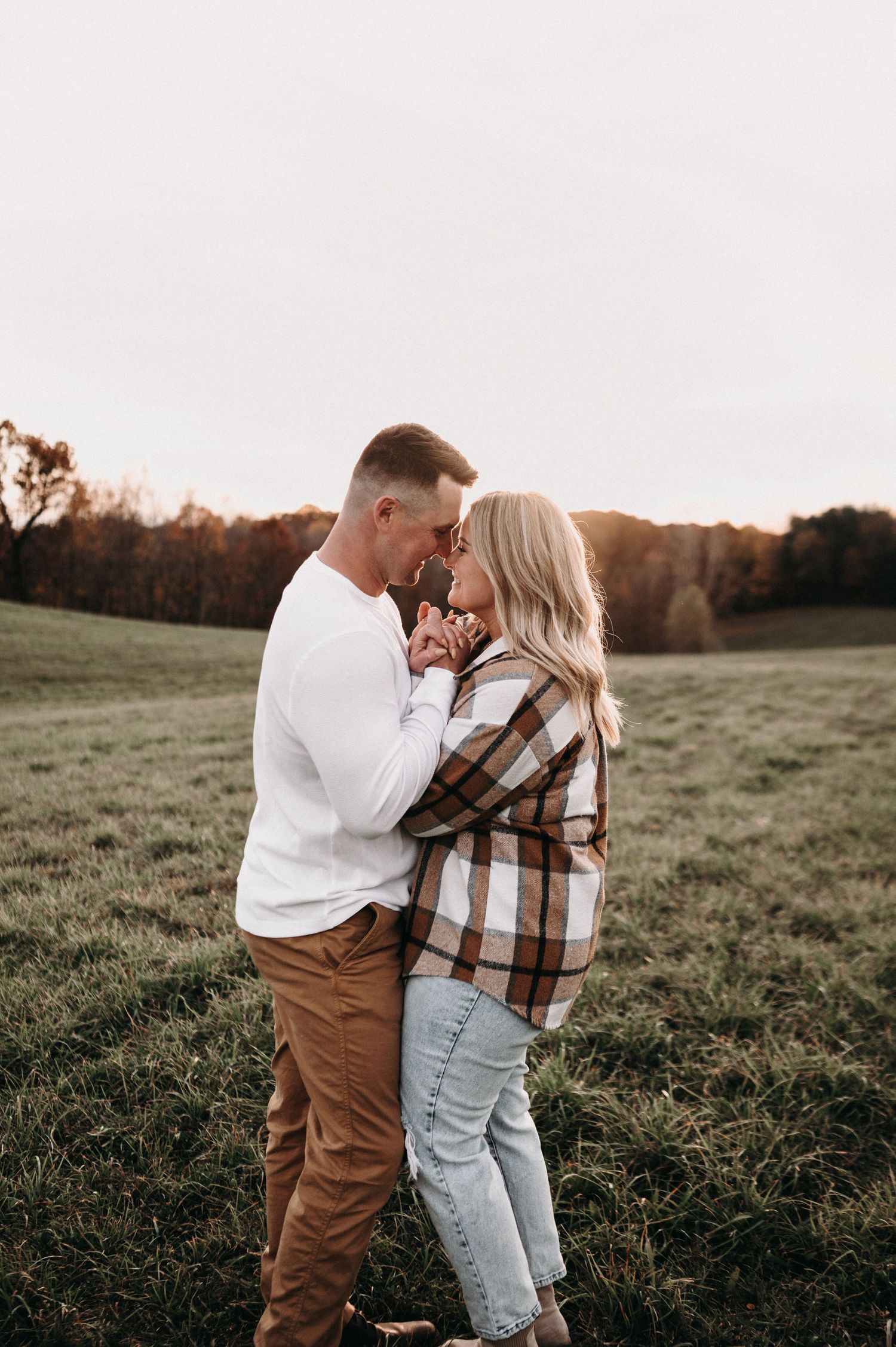 Intimate couple moment captured in autumn field at sunset.