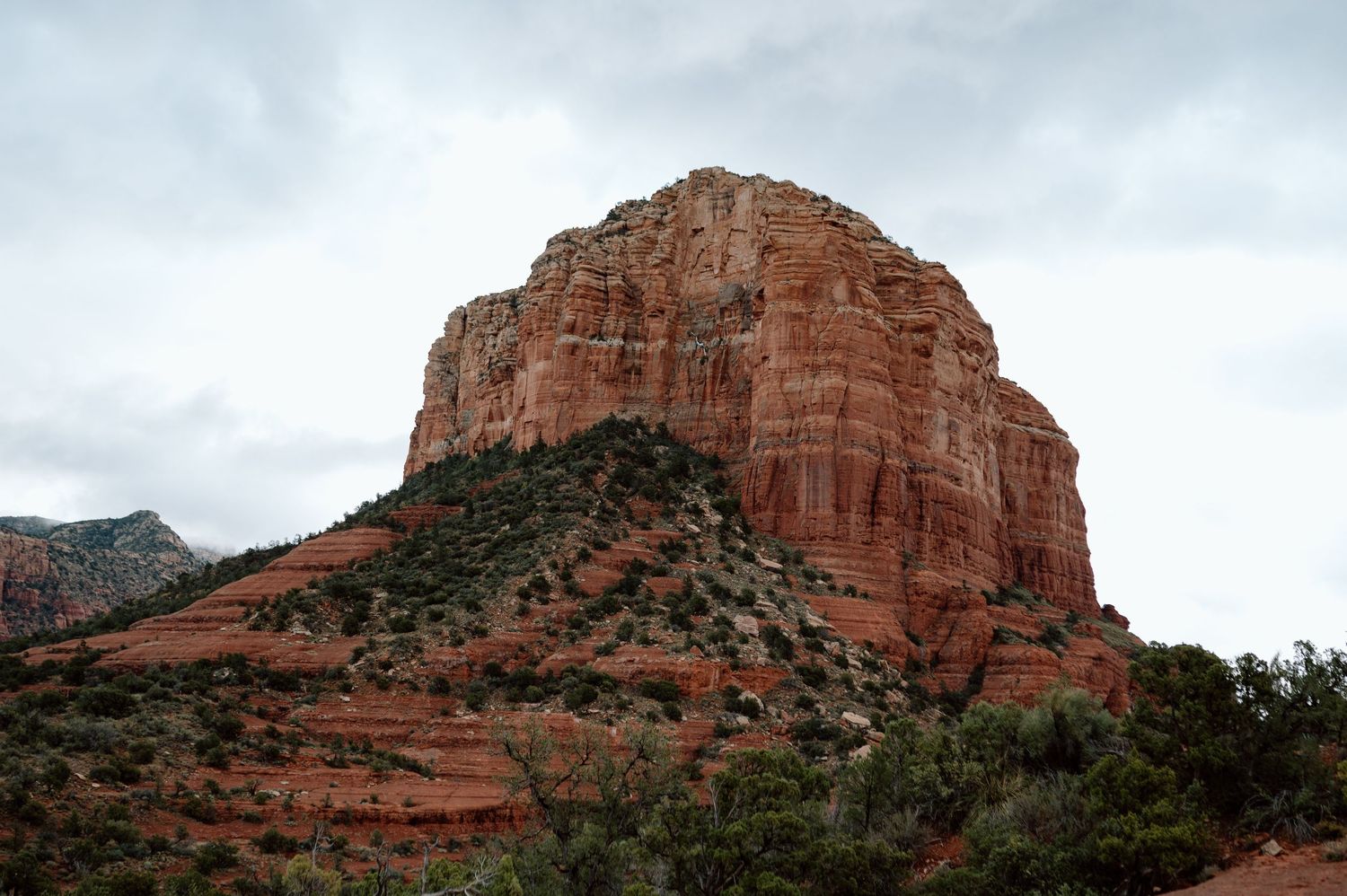 Majestic red rock formation rising against cloudy sky in Sedona, Arizona.