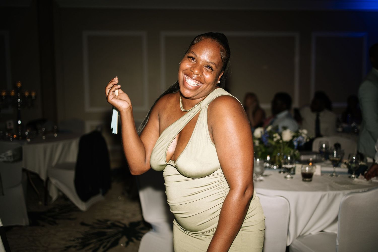 Wedding reception candid moments captured in a dimly lit venue with table settings.