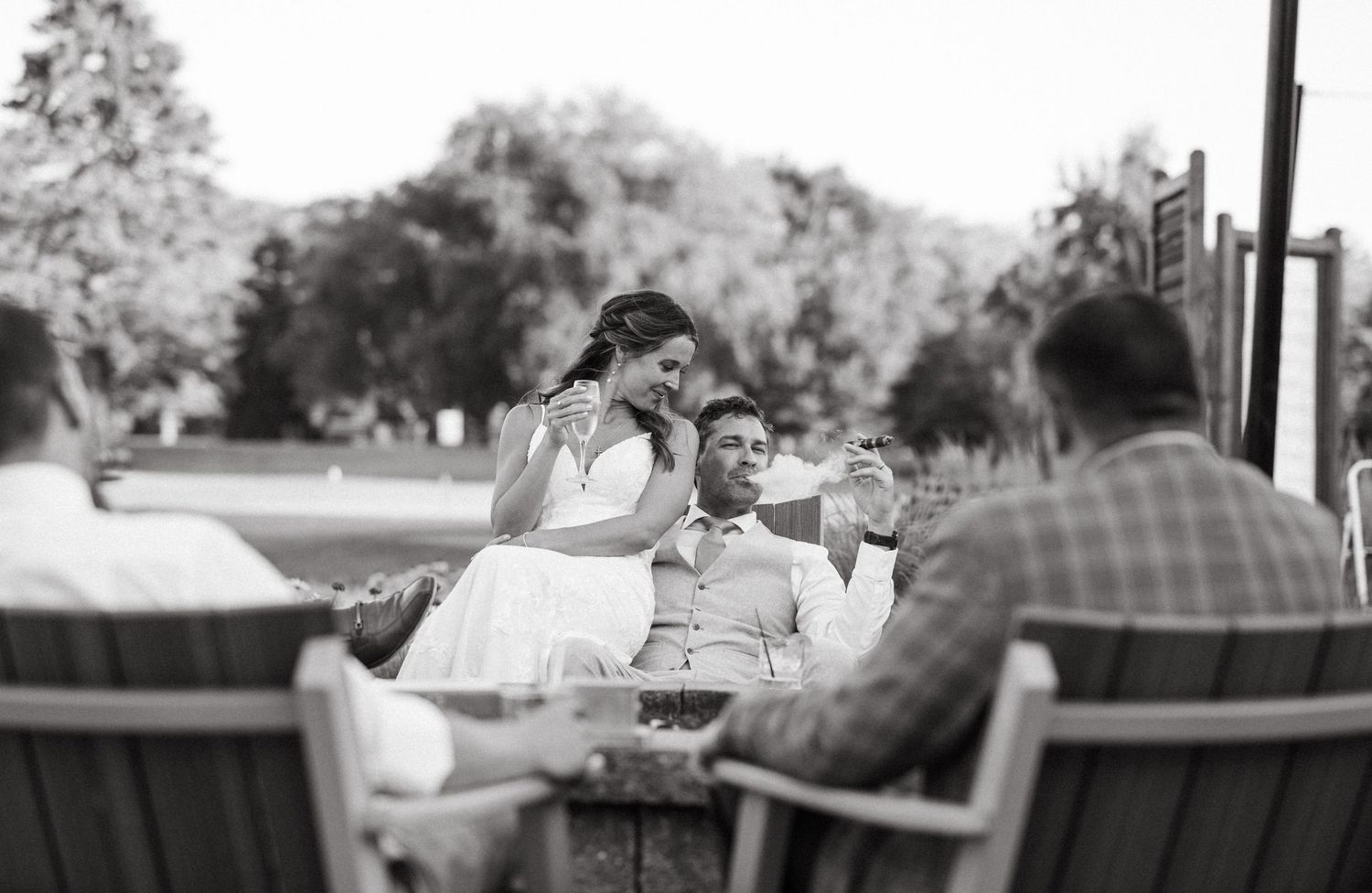Black and white photo of guests enjoying drinks at an outdoor reception.