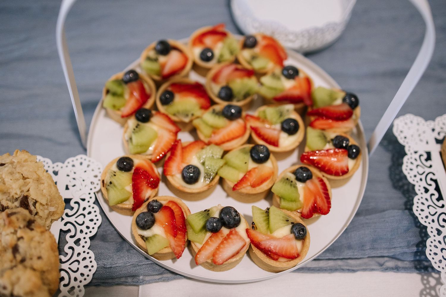 Appetizer platter with bruschetta topped with olives, tomatoes and herbs on lace doilies.