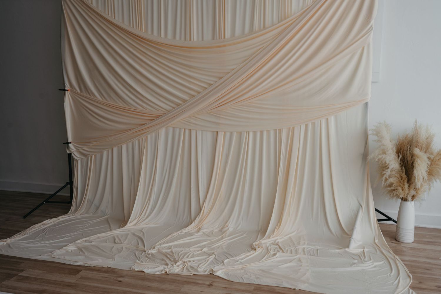 A cream-colored draped fabric backdrop setup for studio photography.