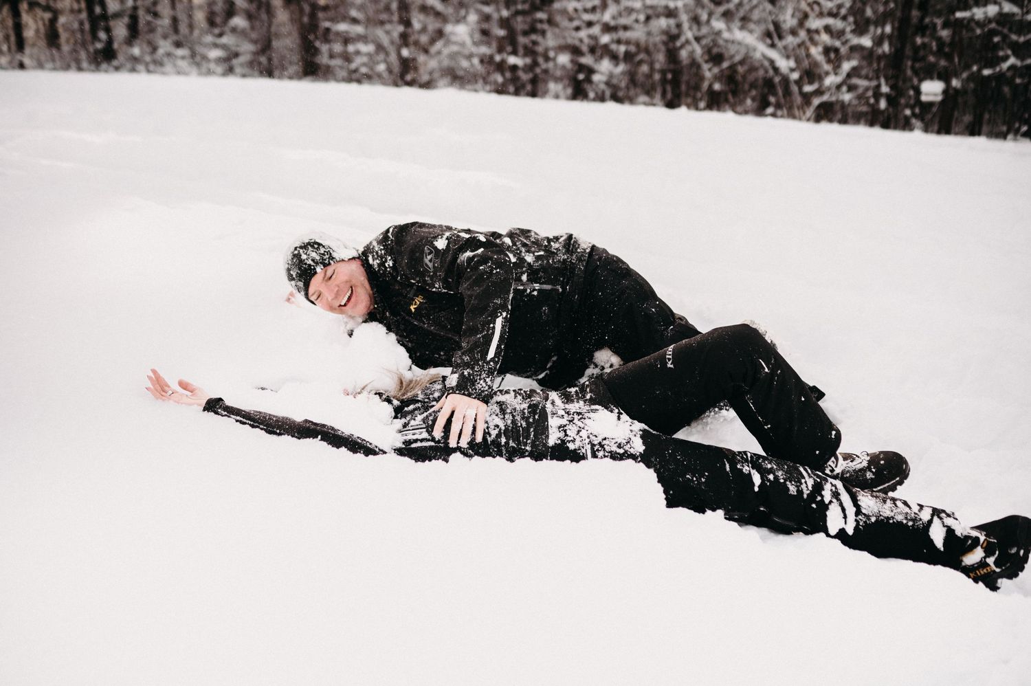 Person lying in fresh powder snow during winter activities.