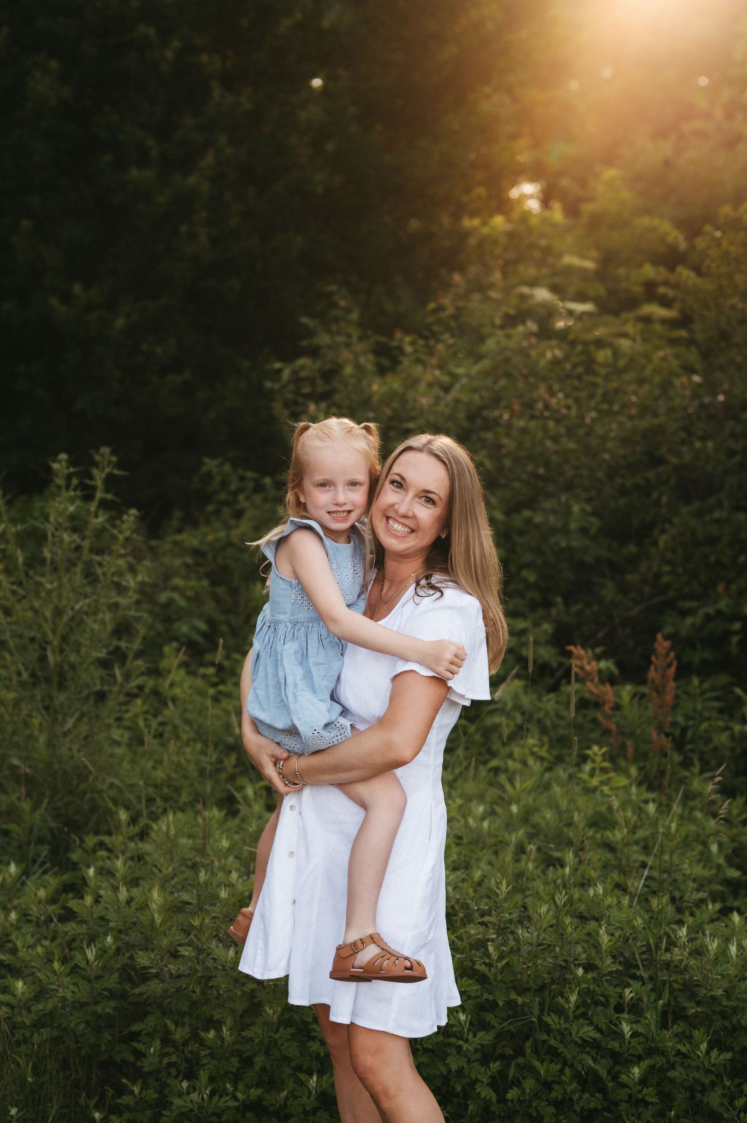 Sweet embrace captured during sunset outdoor family photoshoot with natural backlight.