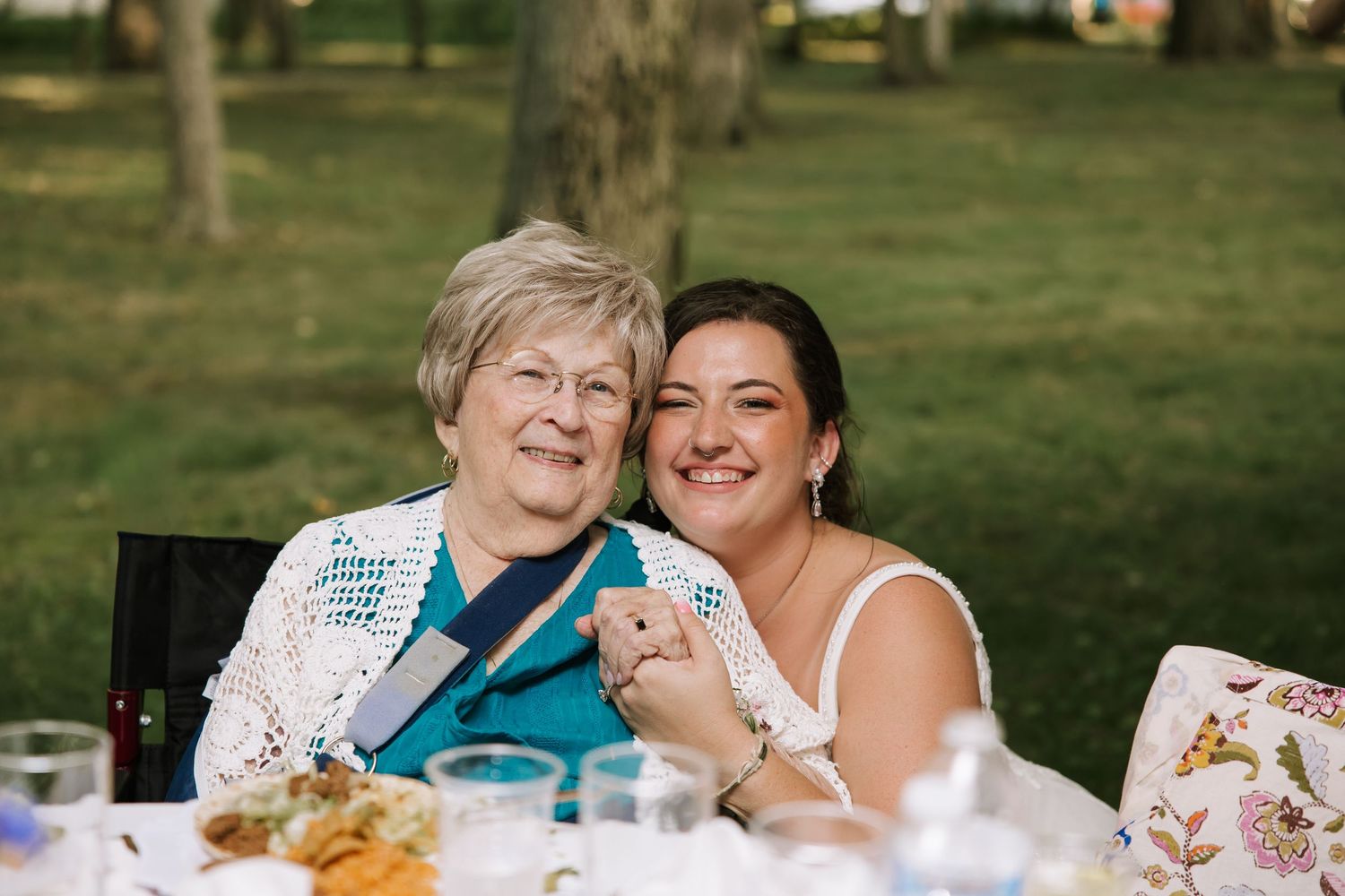 Wedding reception guests enjoying conversation and food at outdoor tables.