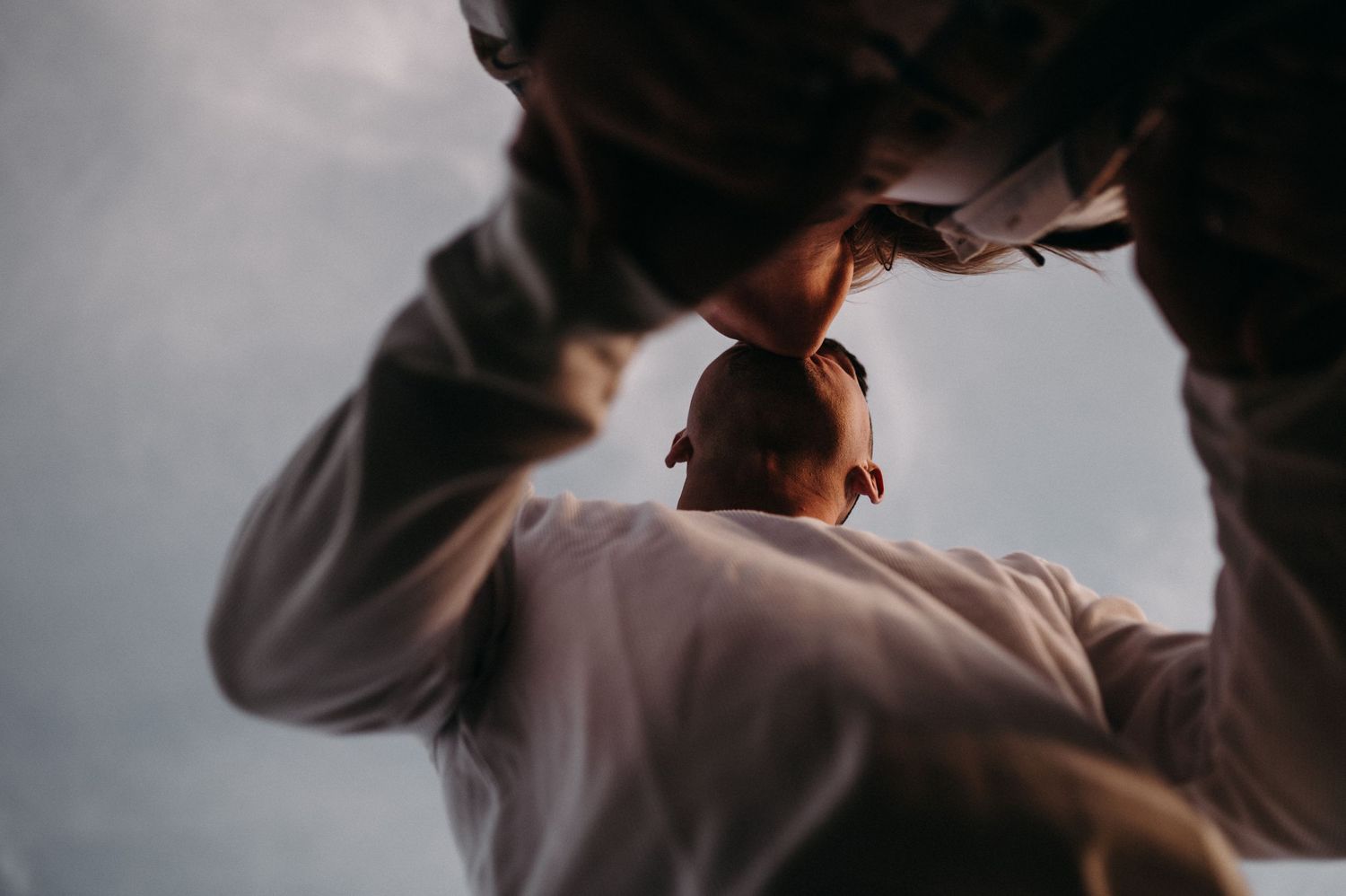 Artistic silhouette photograph of an intimate embrace against moody lighting.