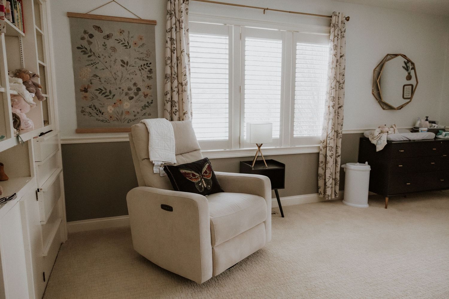 A modern living room interior with white walls, floral curtains and natural lighting.