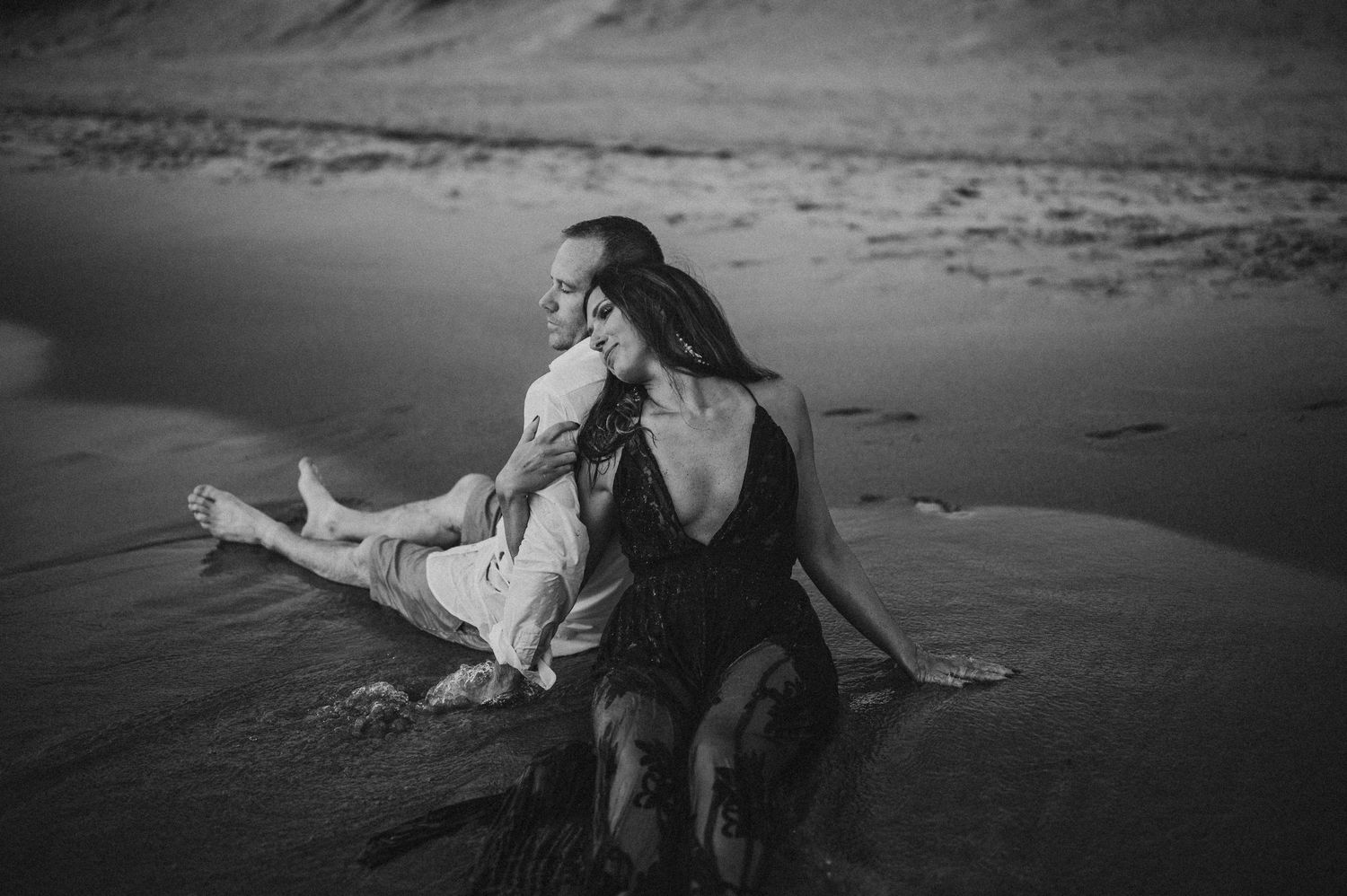 Black and white beach photography series showing intimate couple moments at sunset.