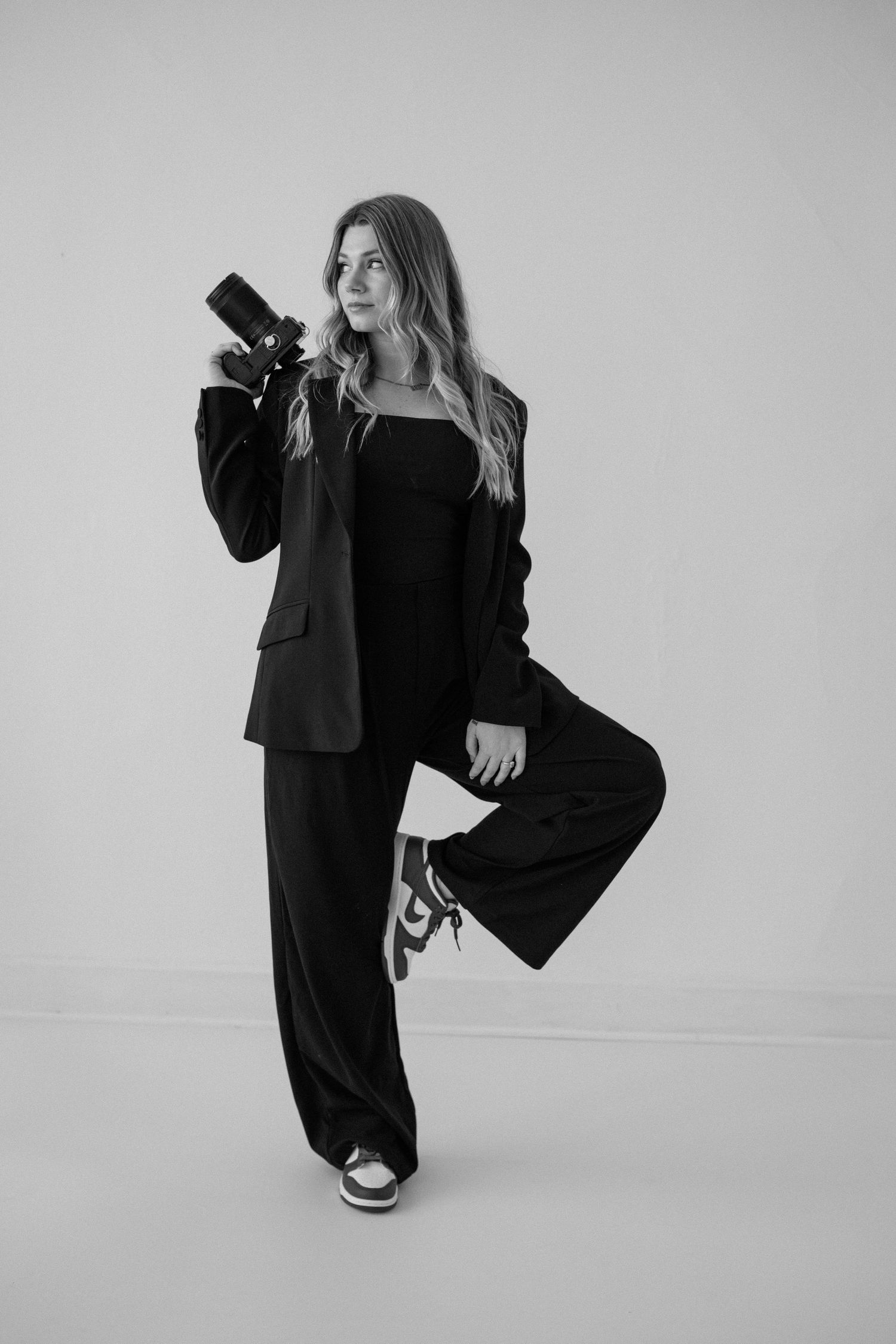 Minimalist fashion photography series featuring poses in black clothing against white background.