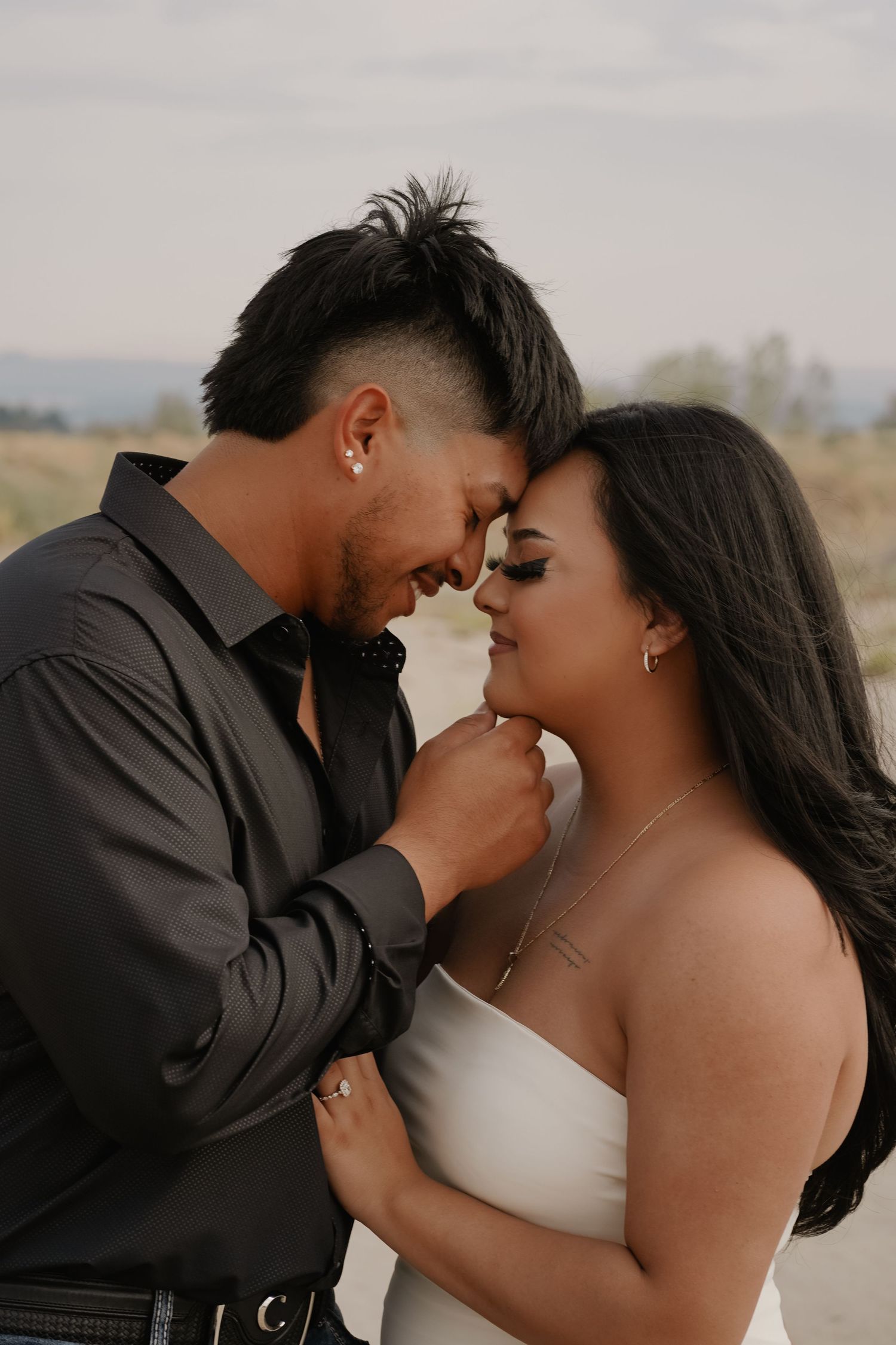 Intimate romantic moment between couple in formal wedding attire.