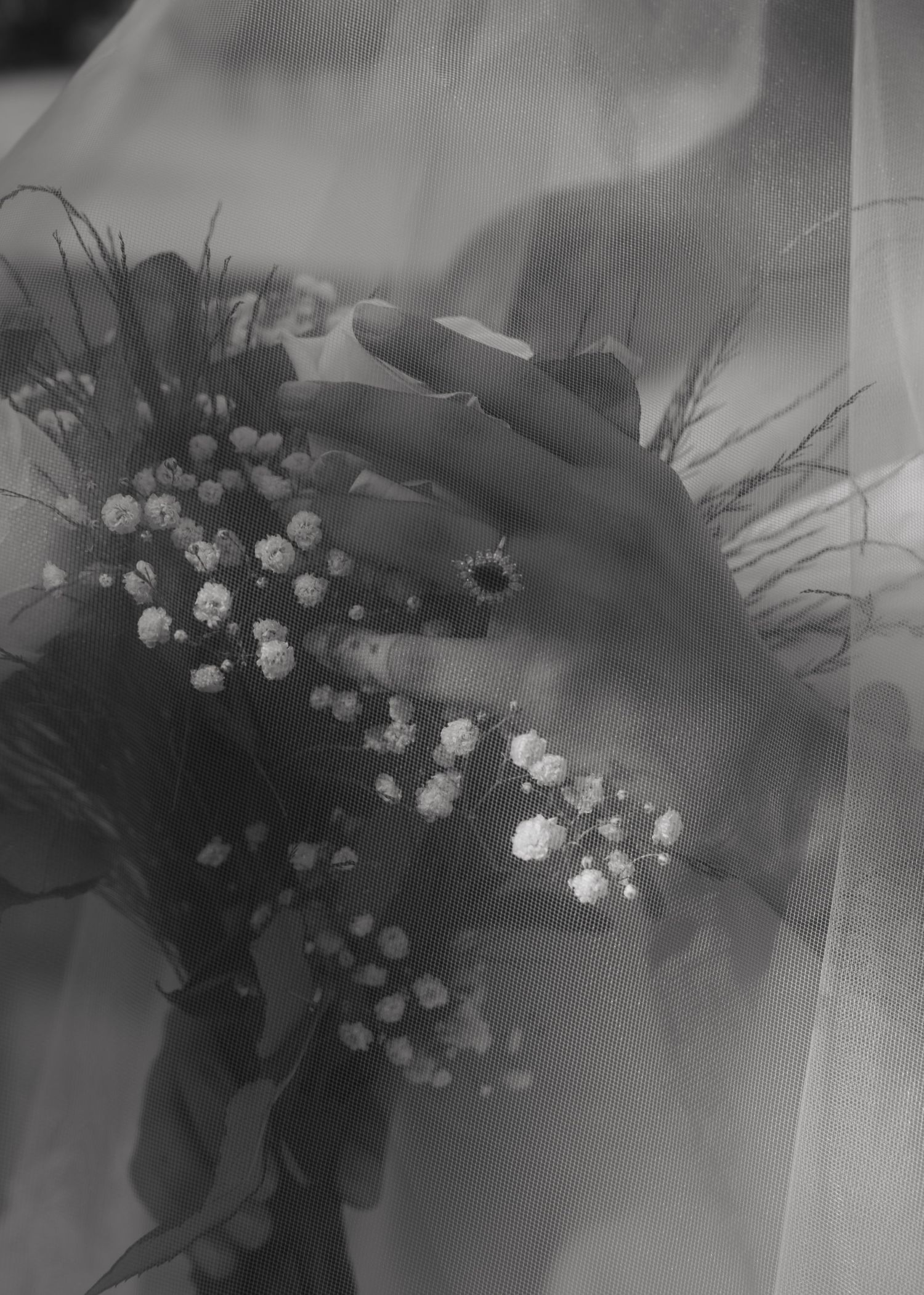 Black and white floral arrangement with delicate white flowers and dark foliage creates an elegant display.