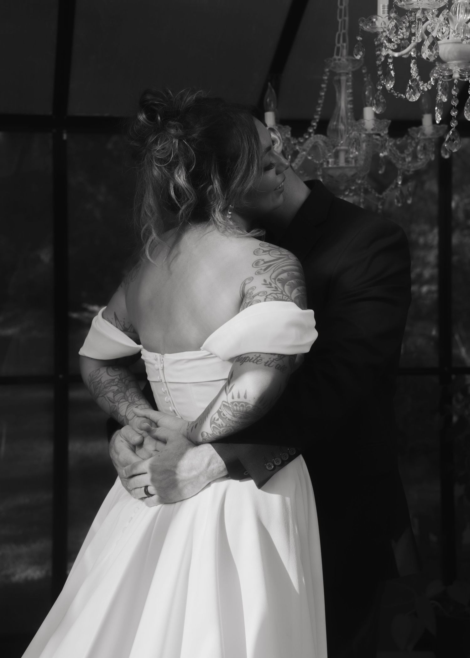 Black and white photo of bride's dress details with delicate lace and pleating.