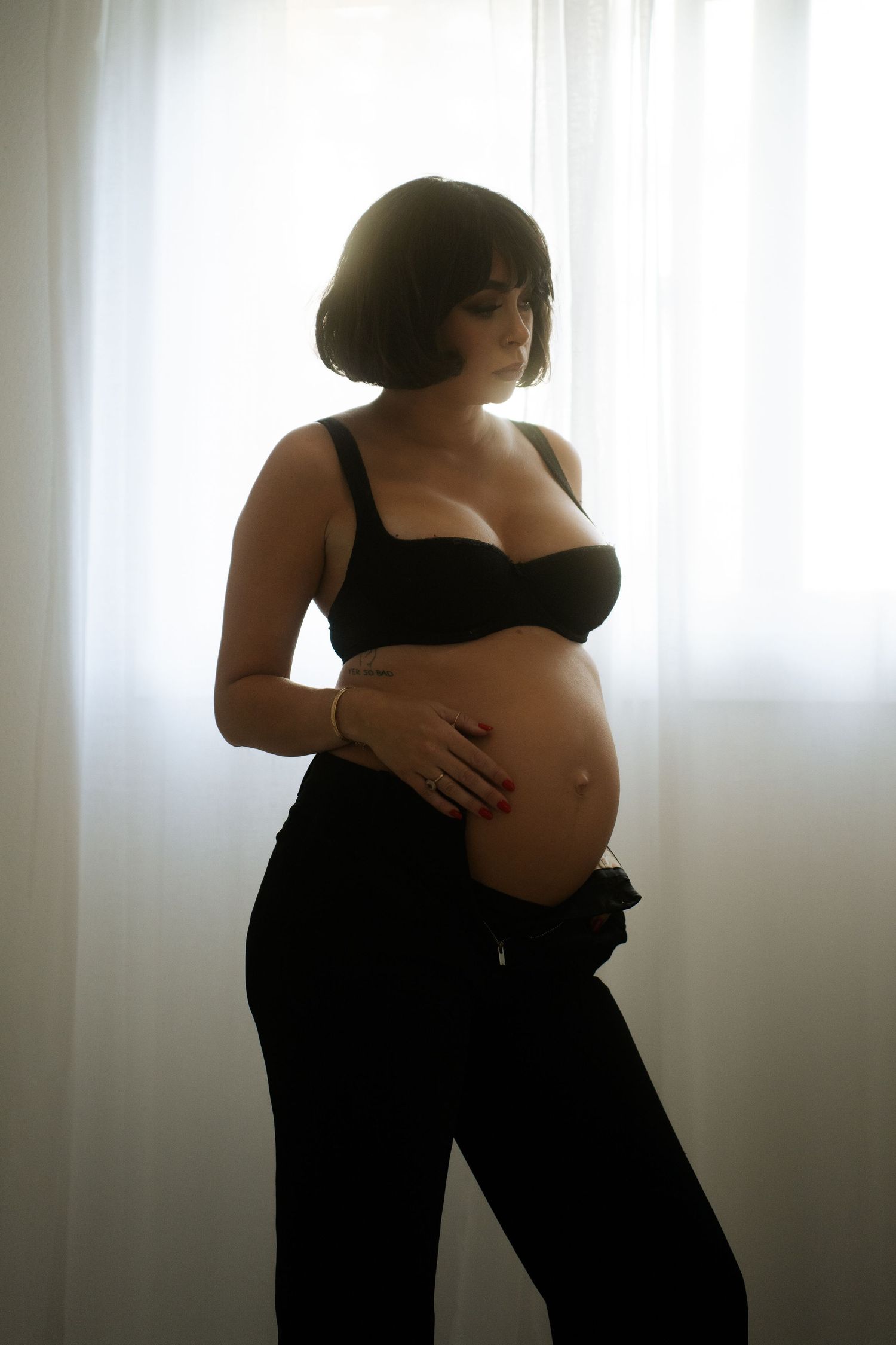Silhouetted maternity portraits against bright window light.
