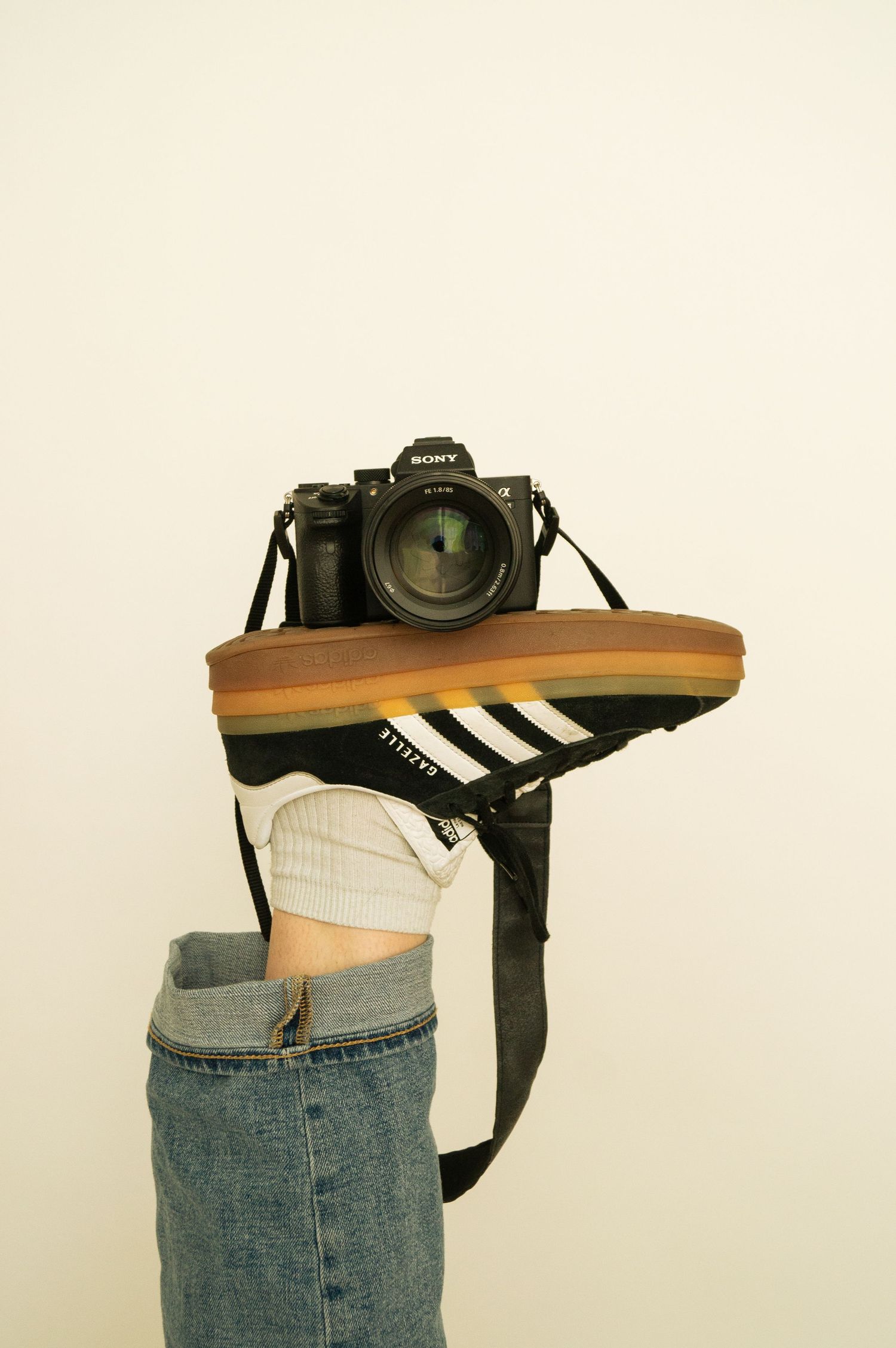Professional camera equipment displayed on denim-clad waist against white background.