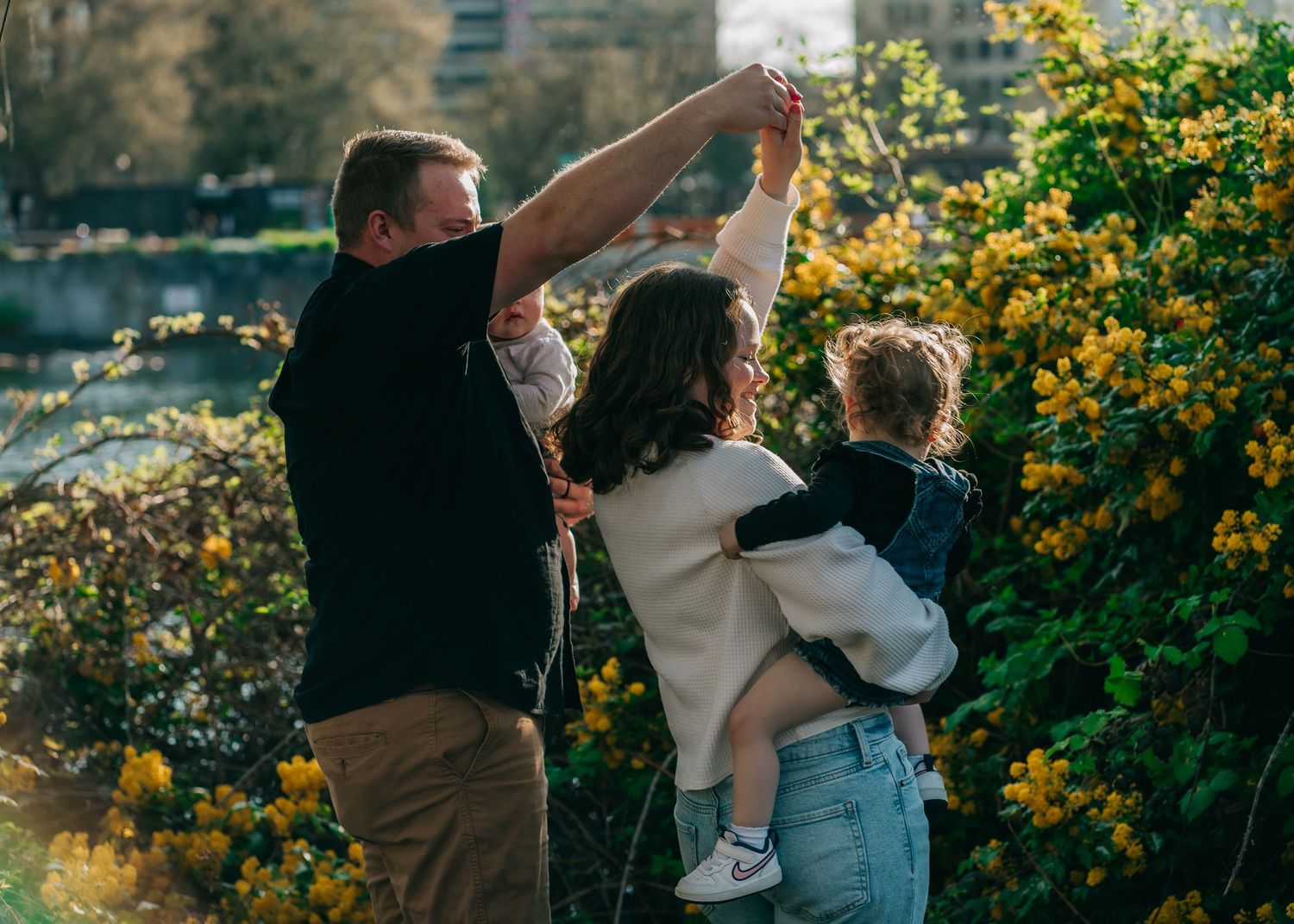 Couple walking together through a garden with blooming yellow flowers in the background.