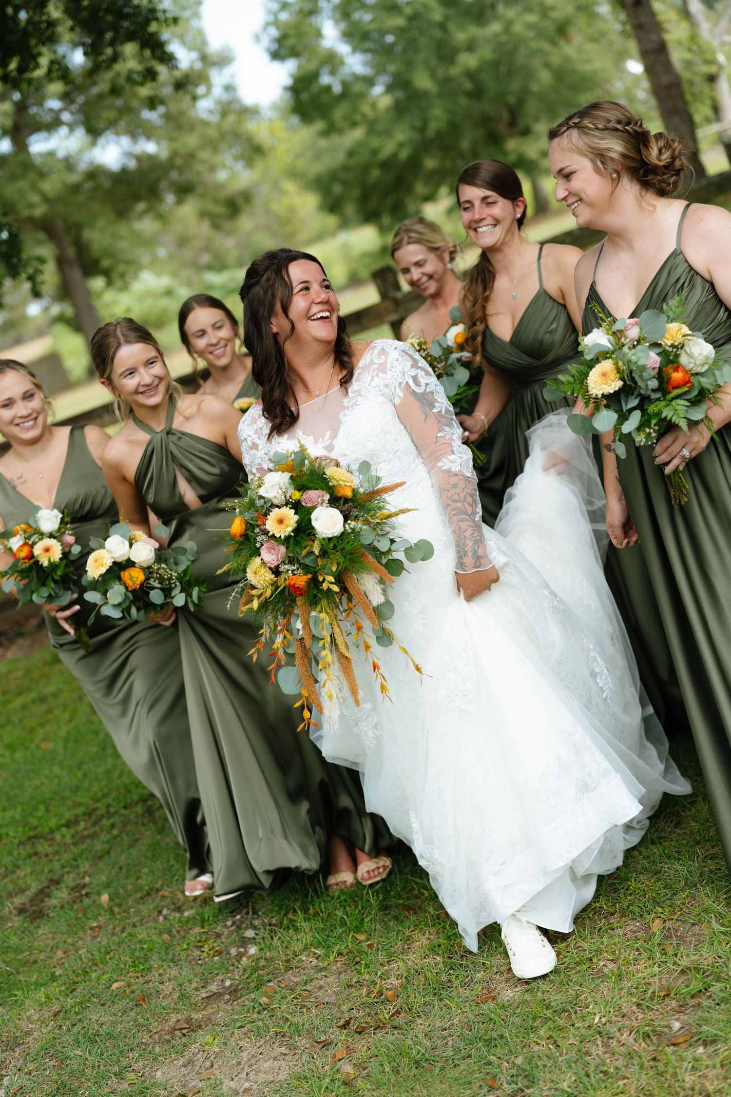 Bride in a white gown with bridesmaids in sage green dresses holding bouquets at an Atlanta wedding