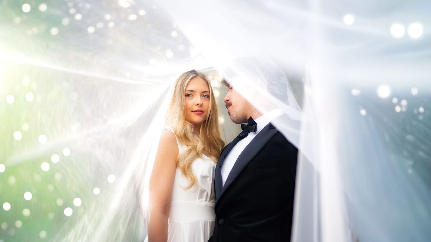 Bride and groom under a dress veil at a Hertfordshire wedding