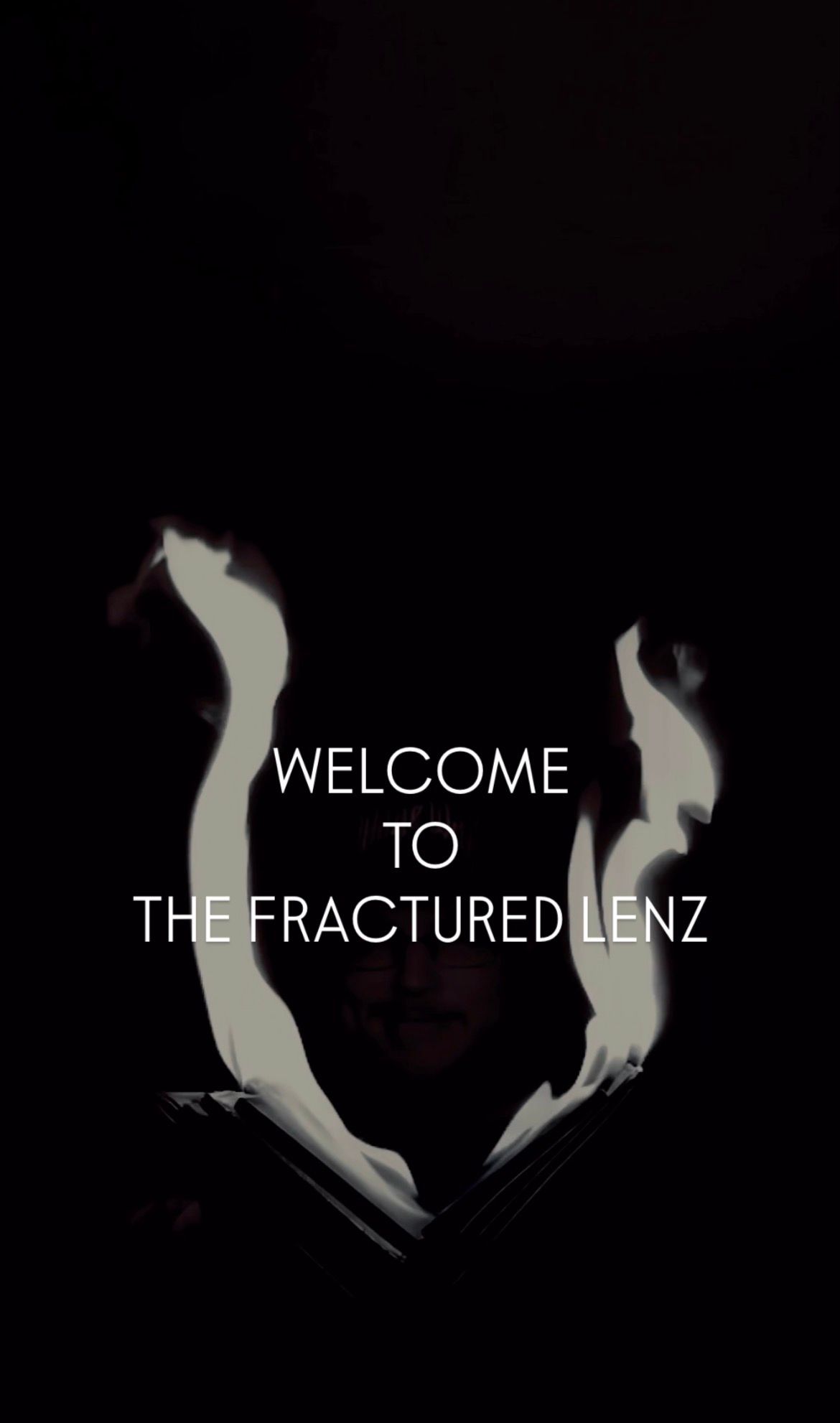 Welcome to The Fractured Lenz text over a dark figure holding a burning book.