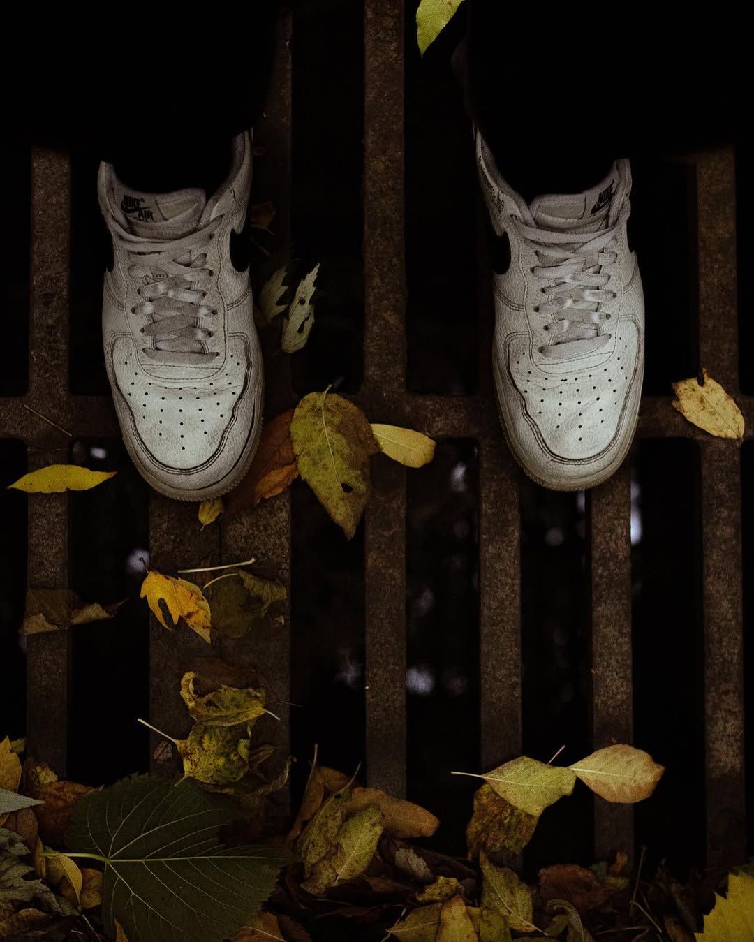 White Nike shoes ständig over an outdoor drain.