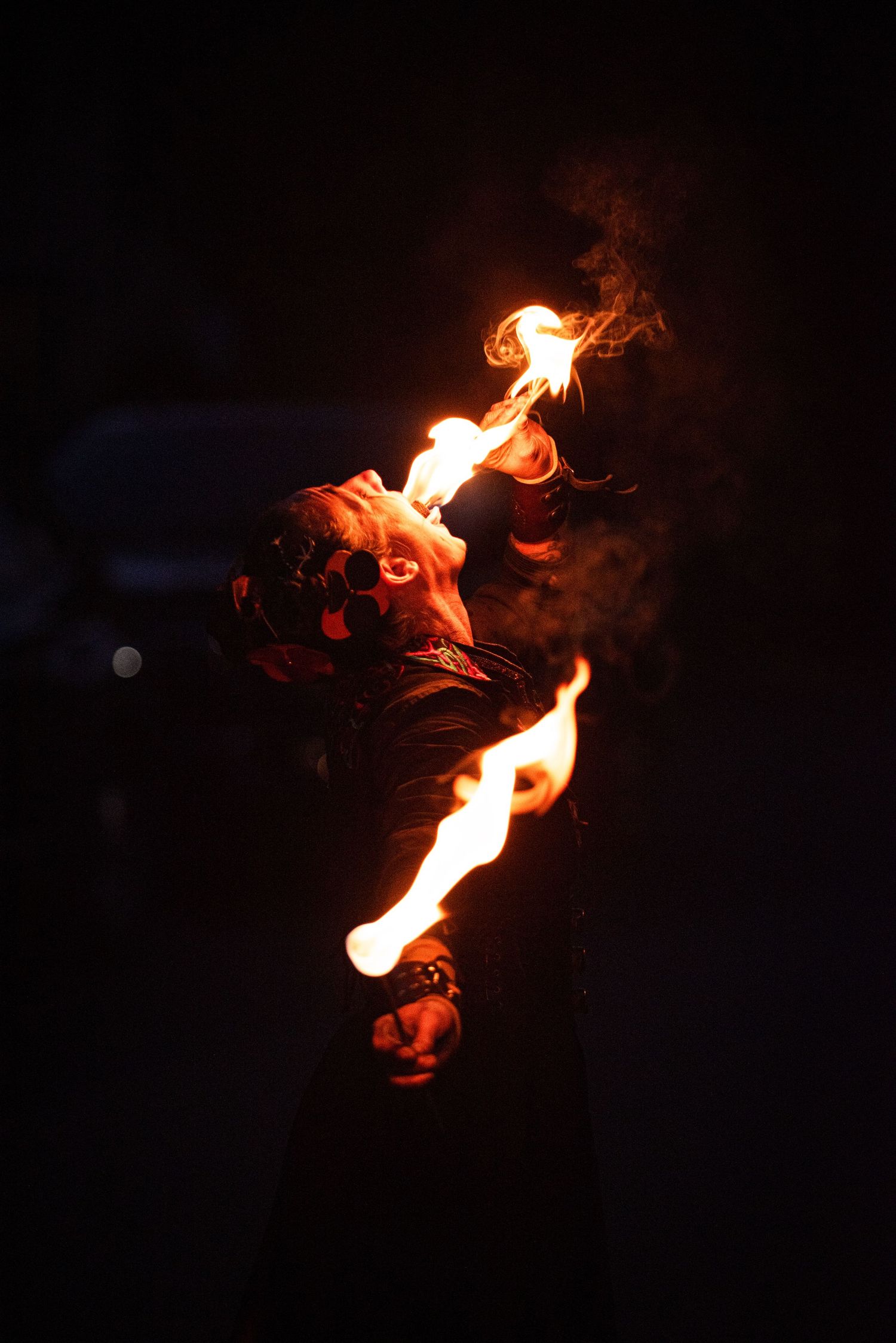 A fire performer breathes flames into the dark night sky during an intense fire-eating show.Outside Monster 
Bash Harmony MN.