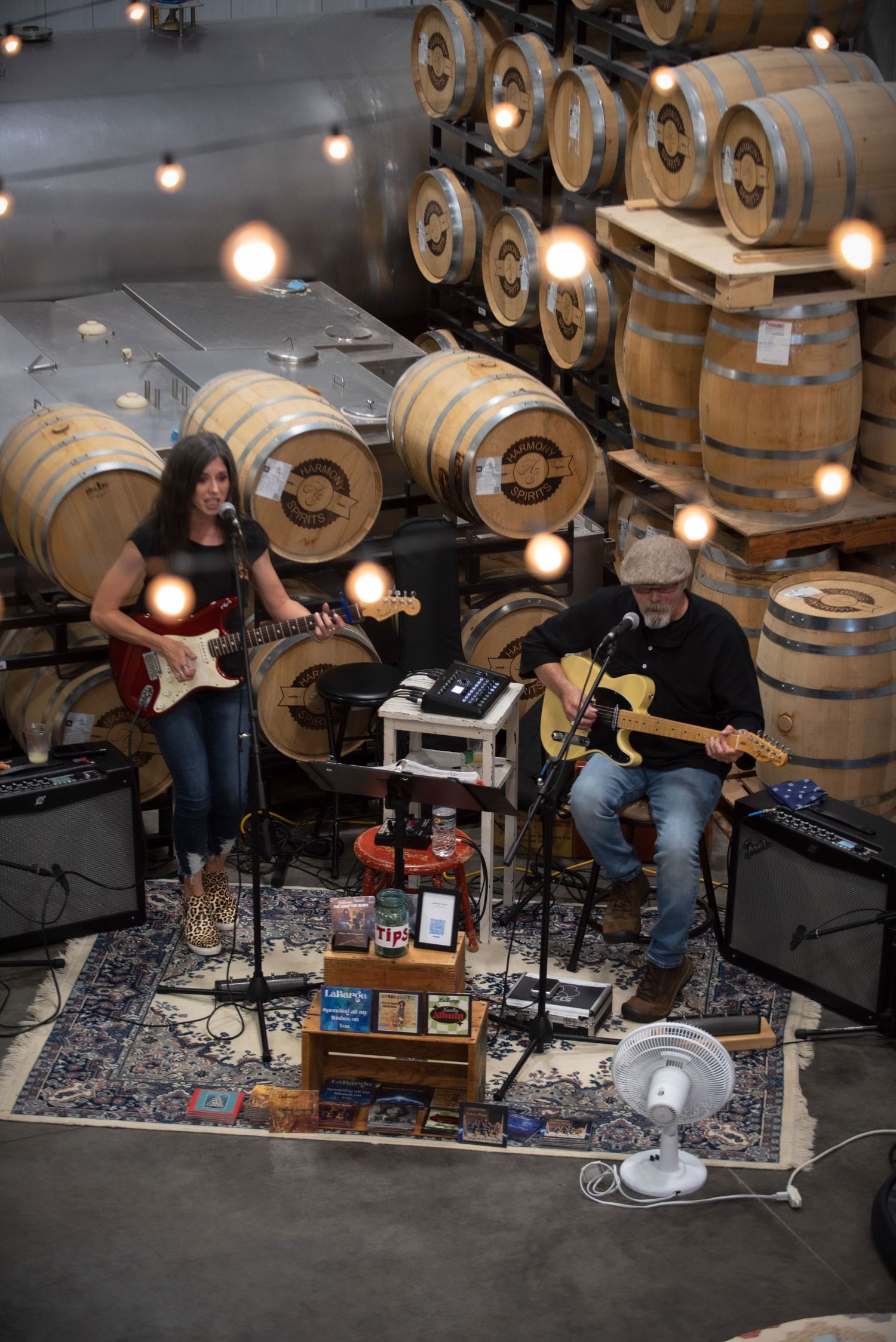 Two musicians playing electric guitars in a barrel room performance at Harmony Spirits..