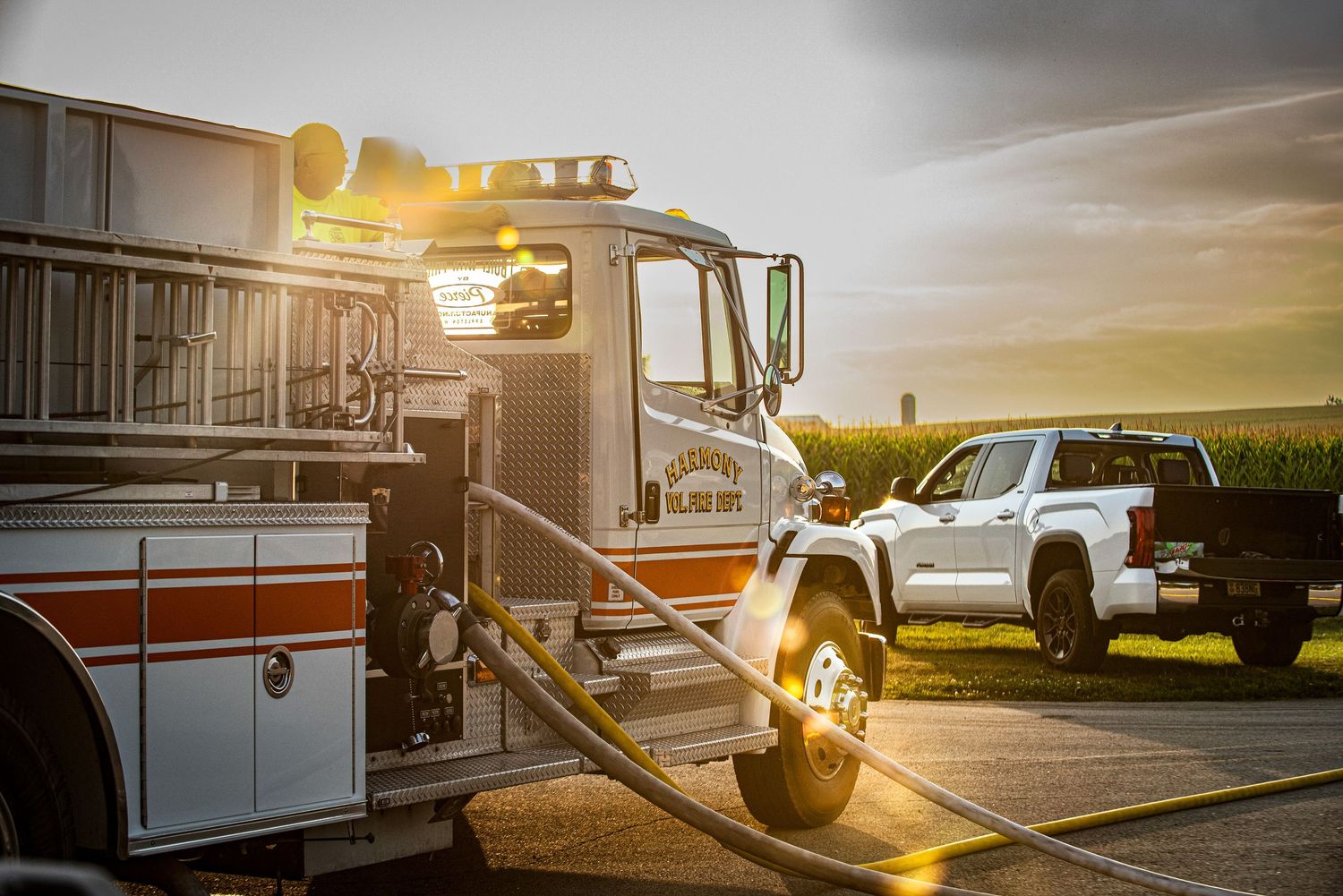 Fire truck with hose connected parked at sunset during an practice emergency response.