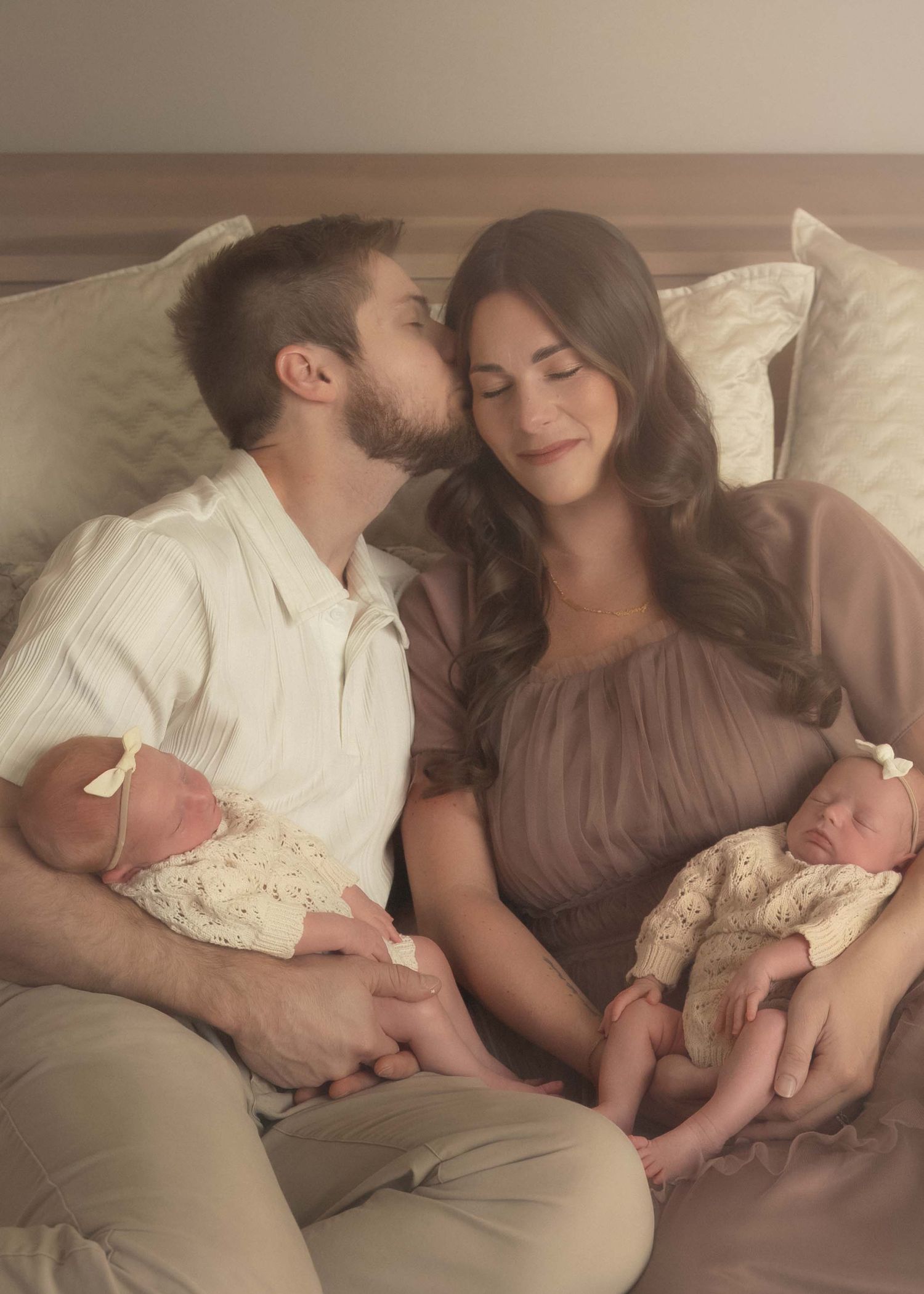 Parents holding newborn twins during an intimate studio newborn photography session.