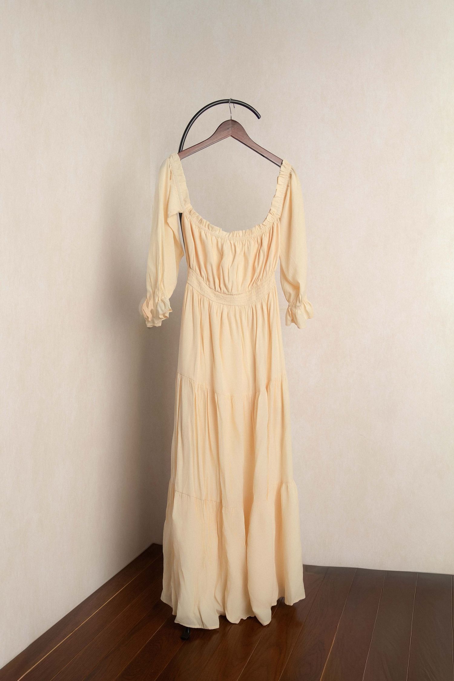 Elegant cream chiffon maxi dress with puff sleeves and tiered skirt on a hanger.