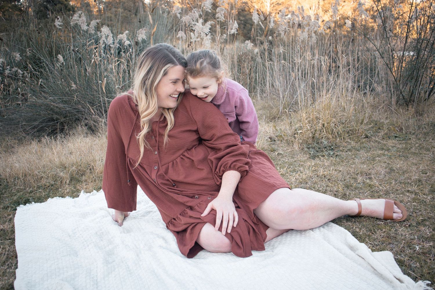 Newcastle family session with mother and daughter sitting on blanket laughing together in nature