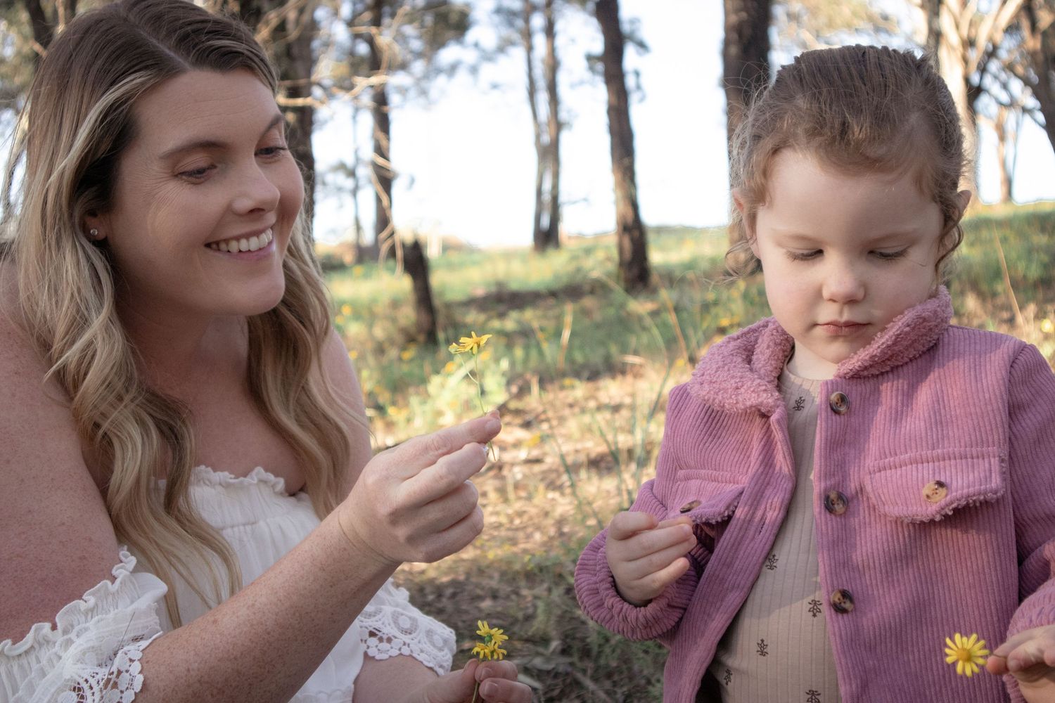 Mother and daughter picking flowers during relaxed outdoor family photography session