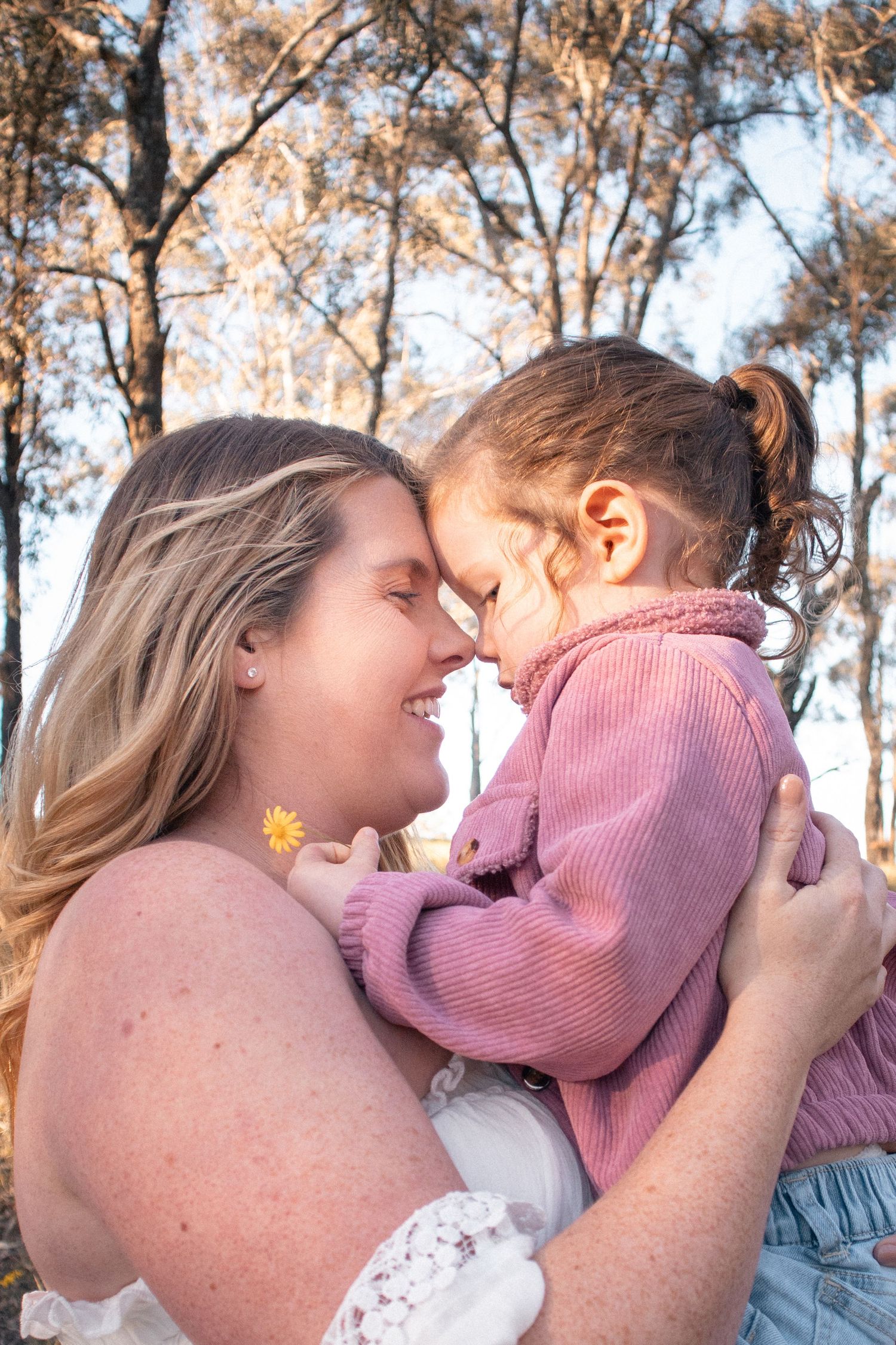 Hunter Valley family photography of mother holding toddler close outdoors in warm golden light