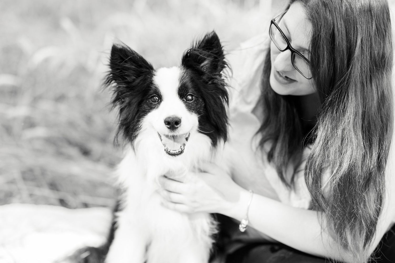 Black and white border collie poses with companion in black and white portrait.