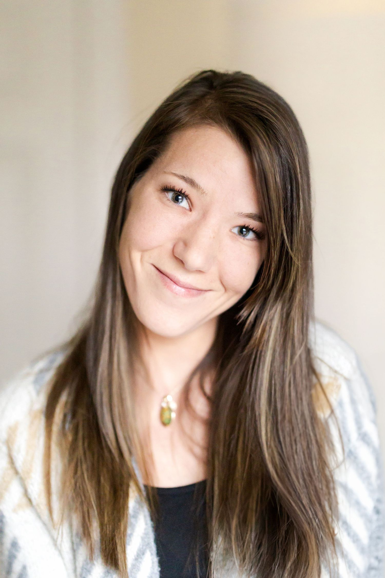 Portrait of a woman with long brown hair against a light background.