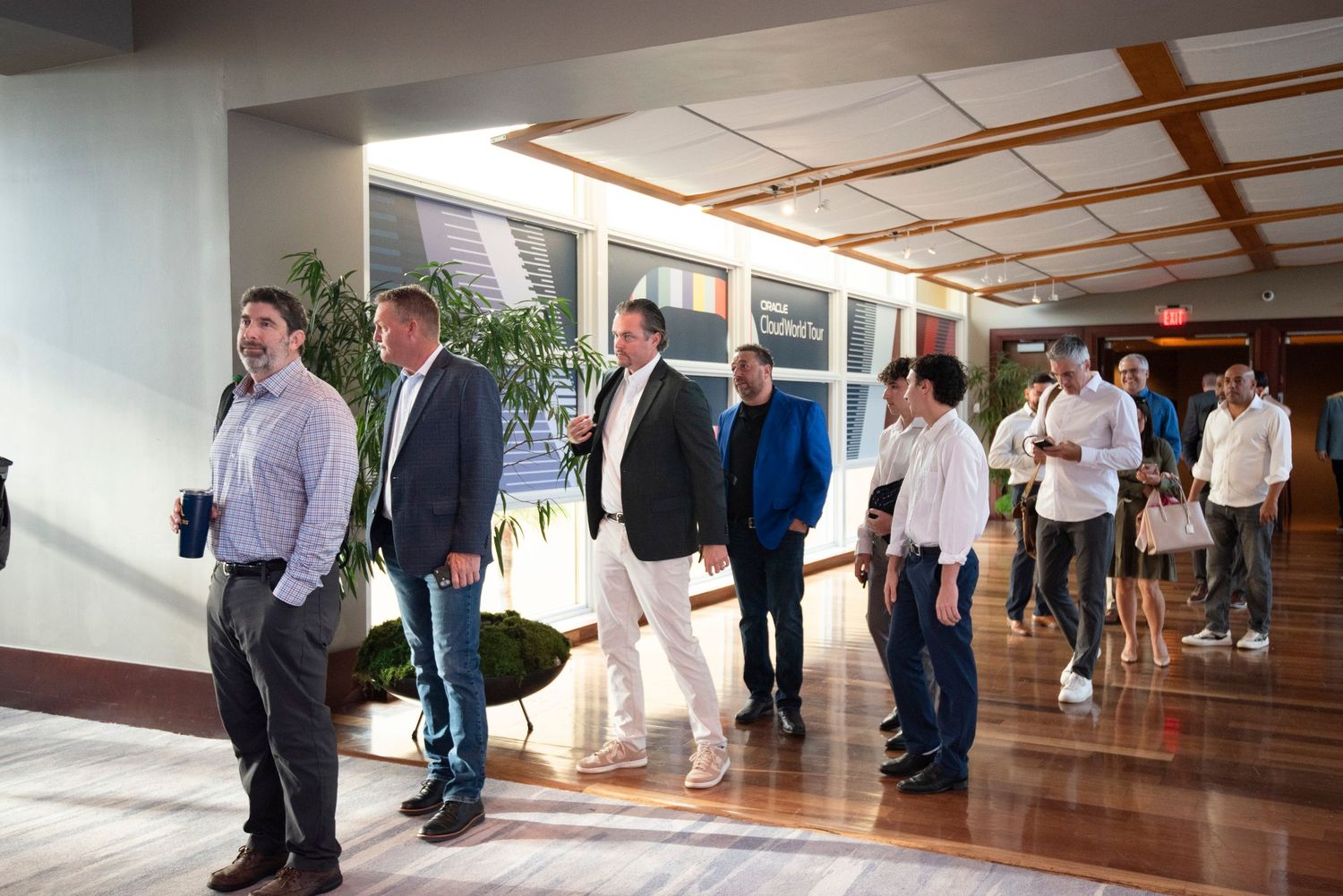 Business professionals networking in a modern conference hall corridor during a corporate event.
