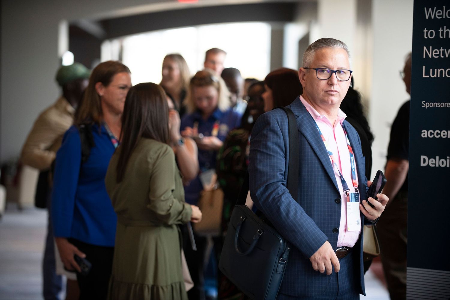 Business professionals networking at a corporate luncheon event in a modern conference center.