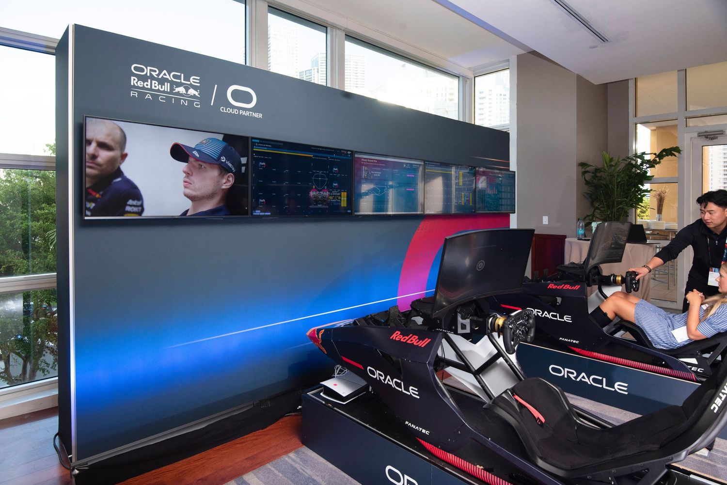 Oracle Red Bull Racing F1 simulator setup with dual racing seats and large display screens in a modern facility.